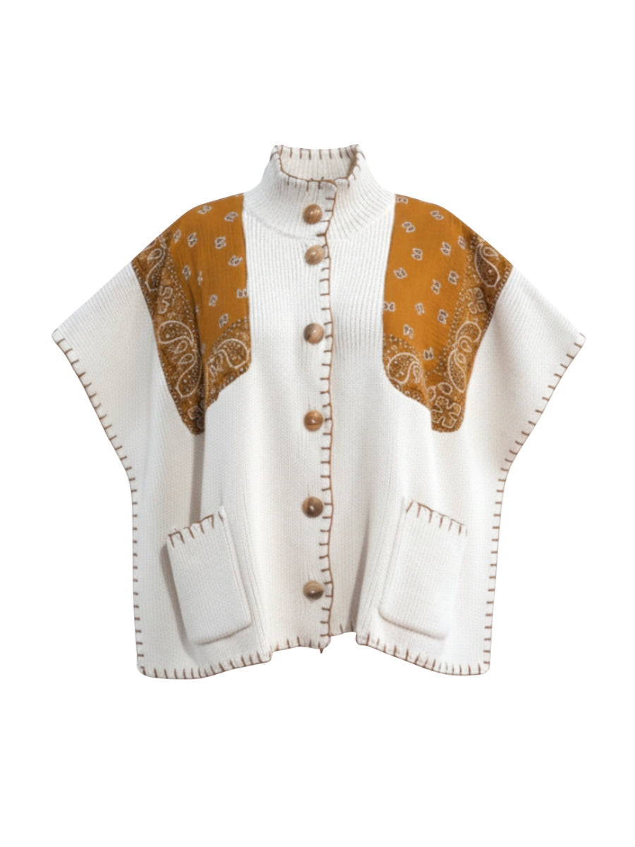 Cream knit outerwear with brown patterned fabric panels on shoulders and wooden buttons down front