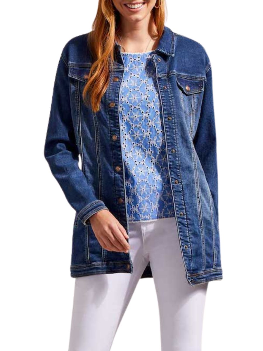 Blue denim jacket over a patterned blue top paired with white pants on a light background