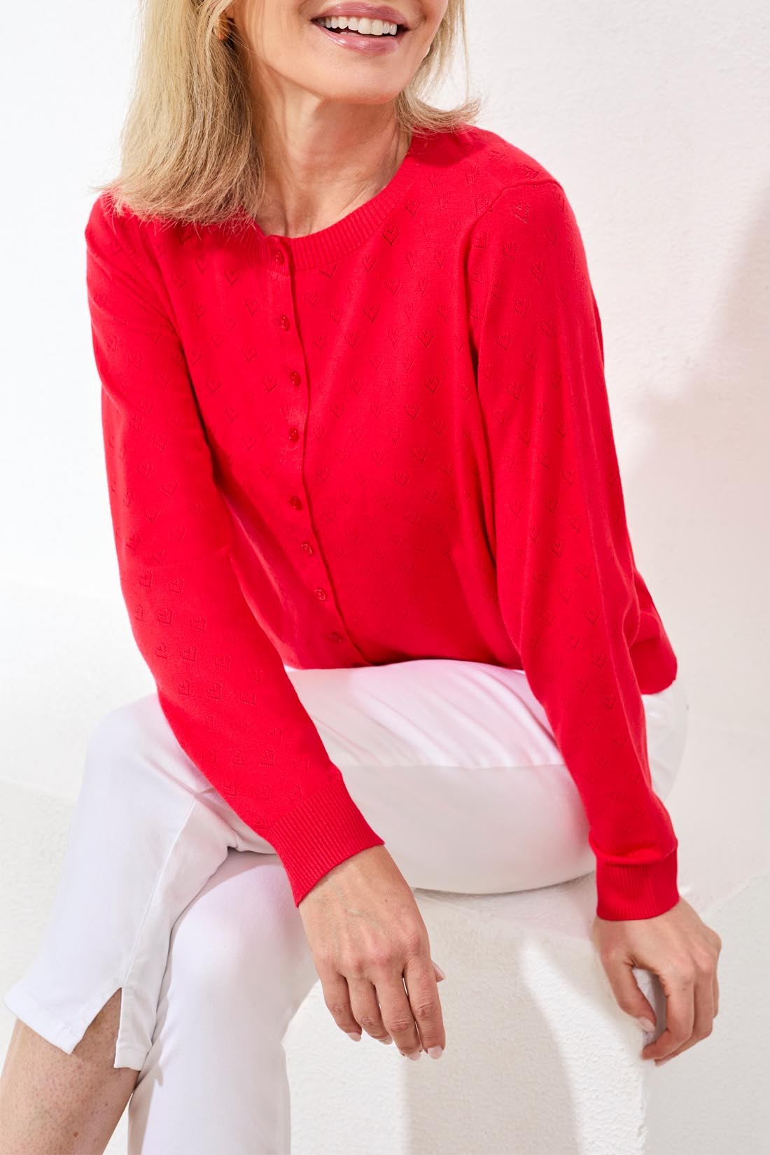Tribal Playful Heart Pointelle Crew Cardigan in vibrant red knit by Tribal Sportswear Inc., styled with white pants.