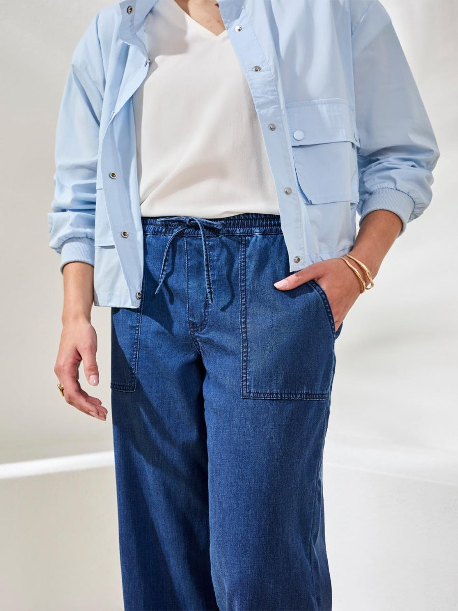 Close-up of Tribal Audrey Tie-Waist 25" Wide-Leg Pants in blue denim styled with light blue jacket by Tribal Sportswear Inc.