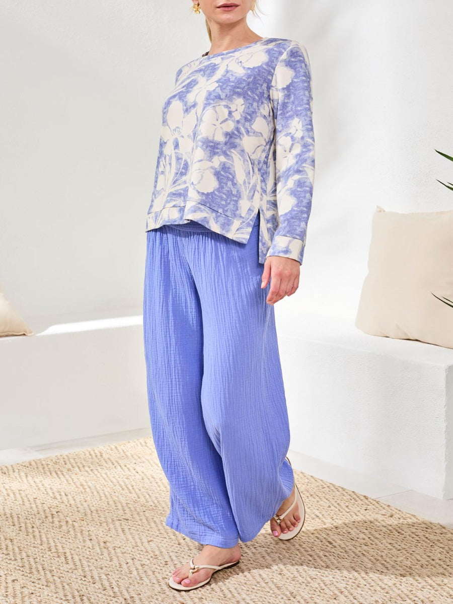 Tribal Lush Oasis Printed Side-Slit Top by Tribal Sportswear Inc. in soft blue floral print, styled with relaxed pants.