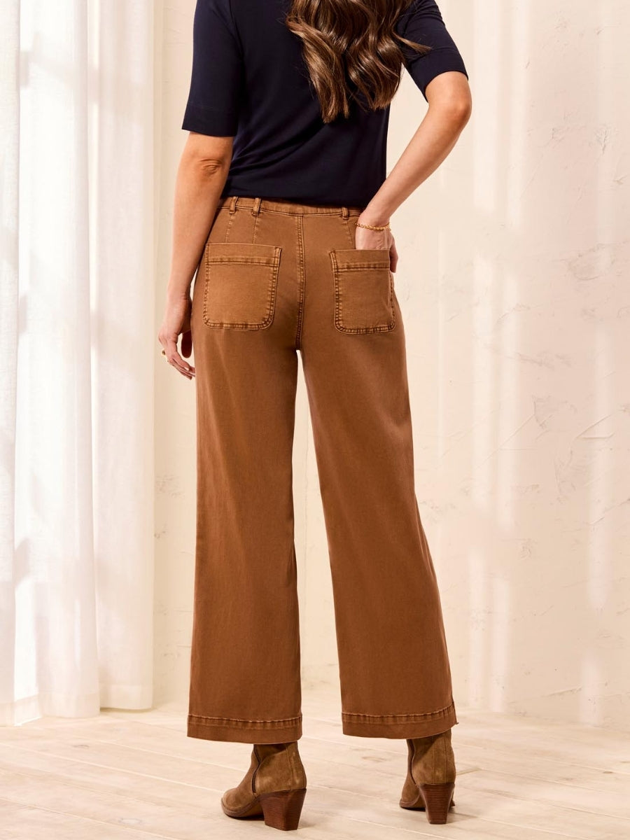 Rear view of brown wide-leg pants with back patch pockets paired with a black top and brown ankle boots.