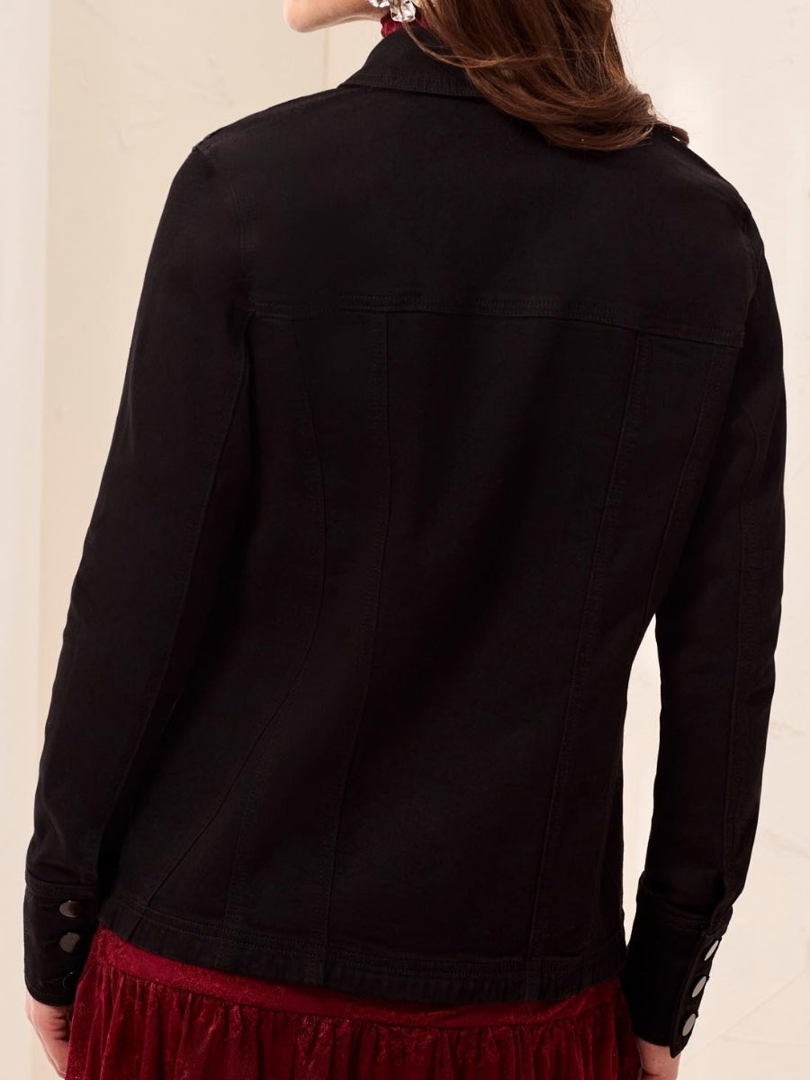 Back view of a fitted black jacket with buttoned cuffs over a red textured skirt or dress.