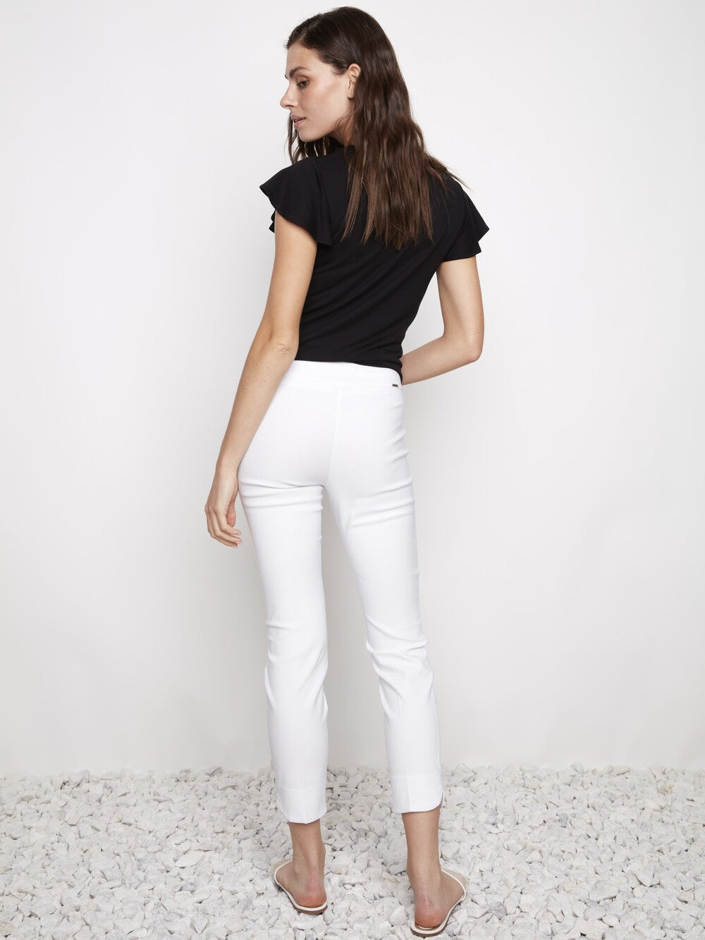 Model showcasing the UP Solid Wrap 28" Petal Slim Pant in white by Up against a plain background