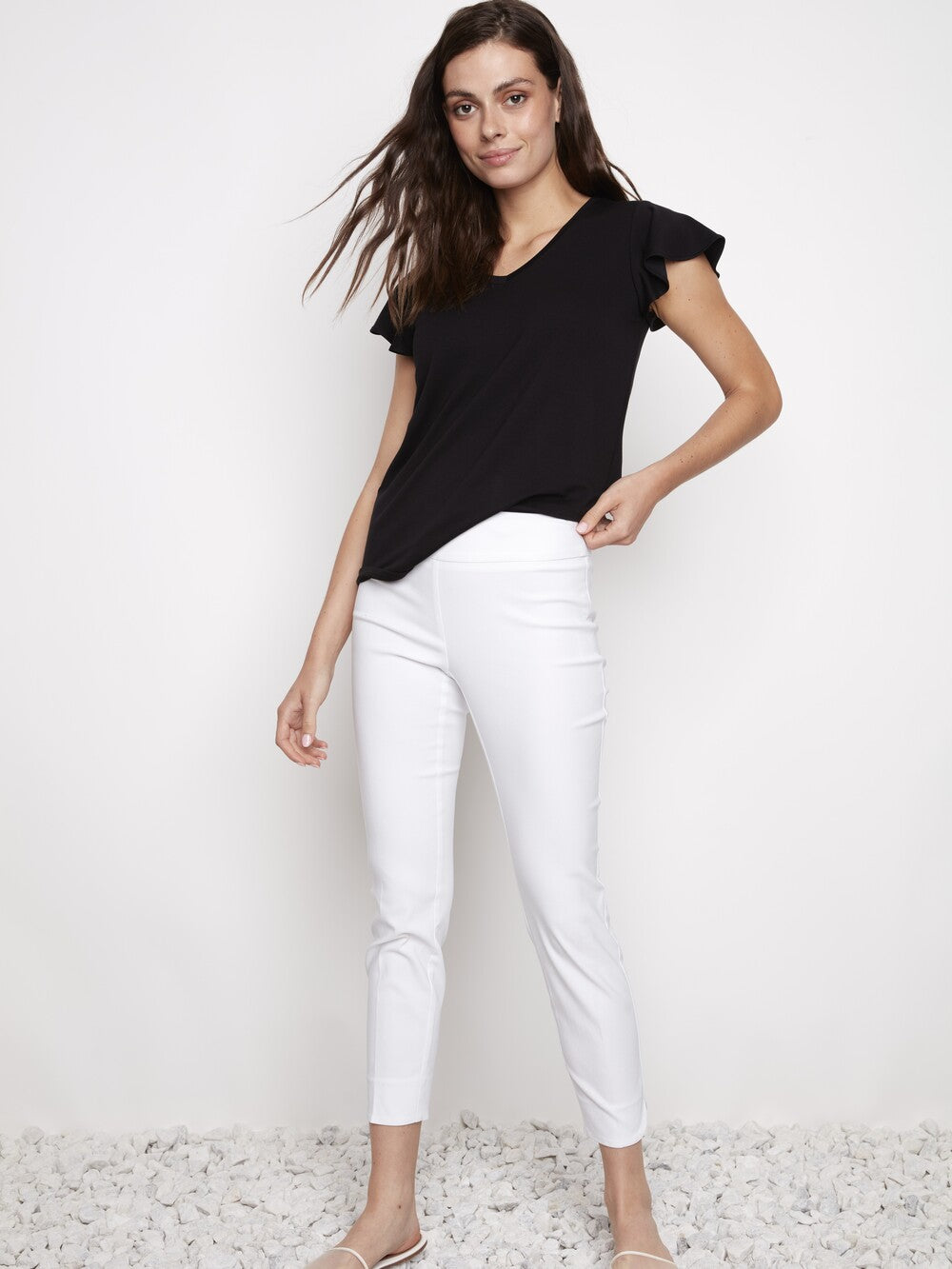 White slim pants styled with a black top, featuring the UP Solid Wrap 28" Petal Slim Pant from Up.