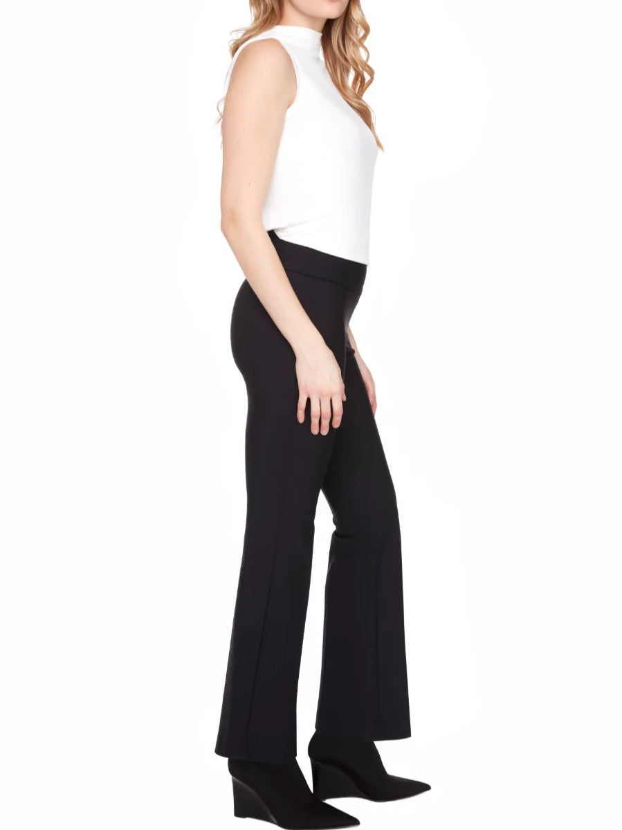 Side view of a sleeveless white top paired with black high-waisted flare pants and black wedge ankle boots