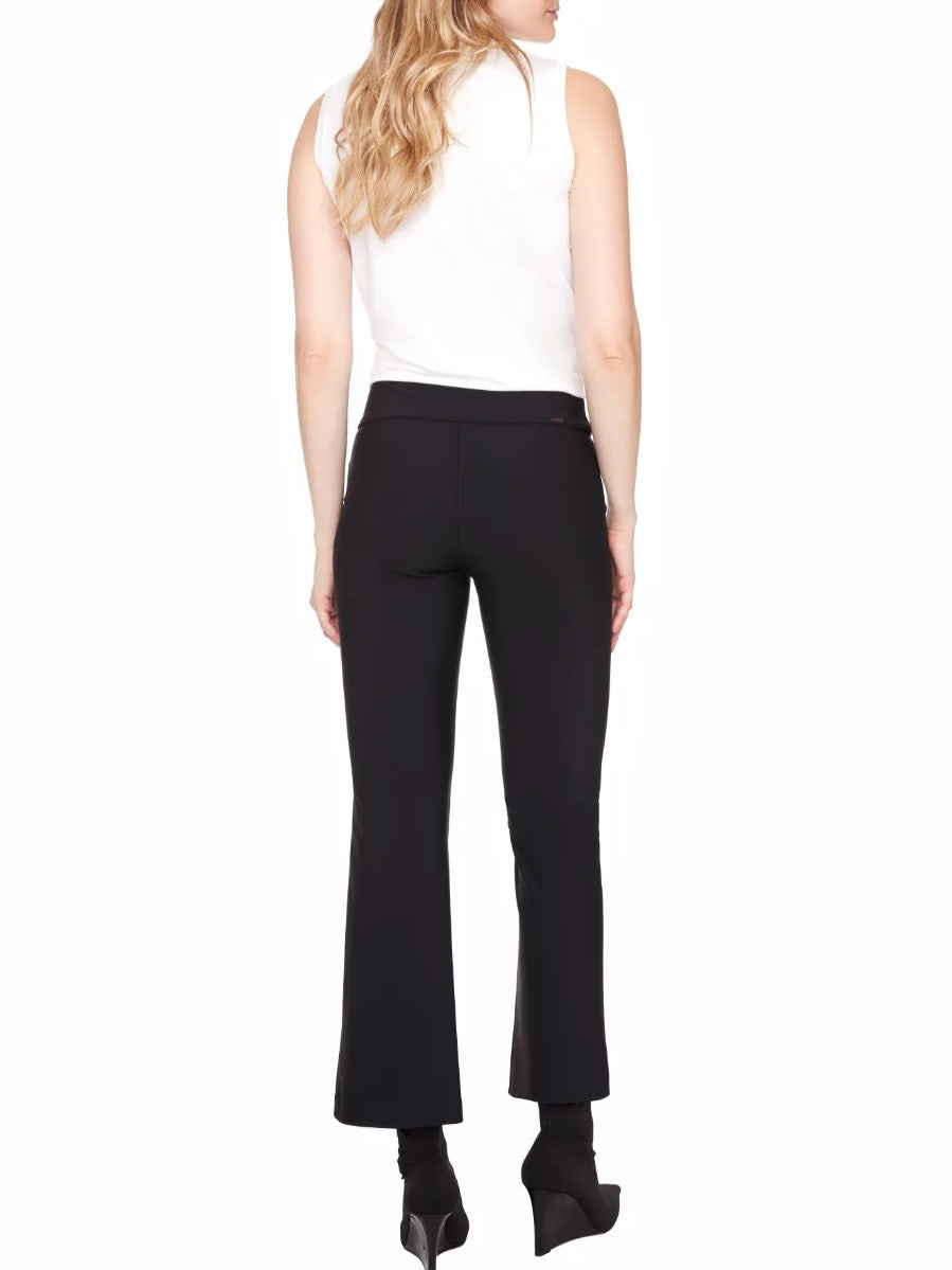 Back view of a sleeveless white top paired with black fitted pants and black heeled ankle boots.