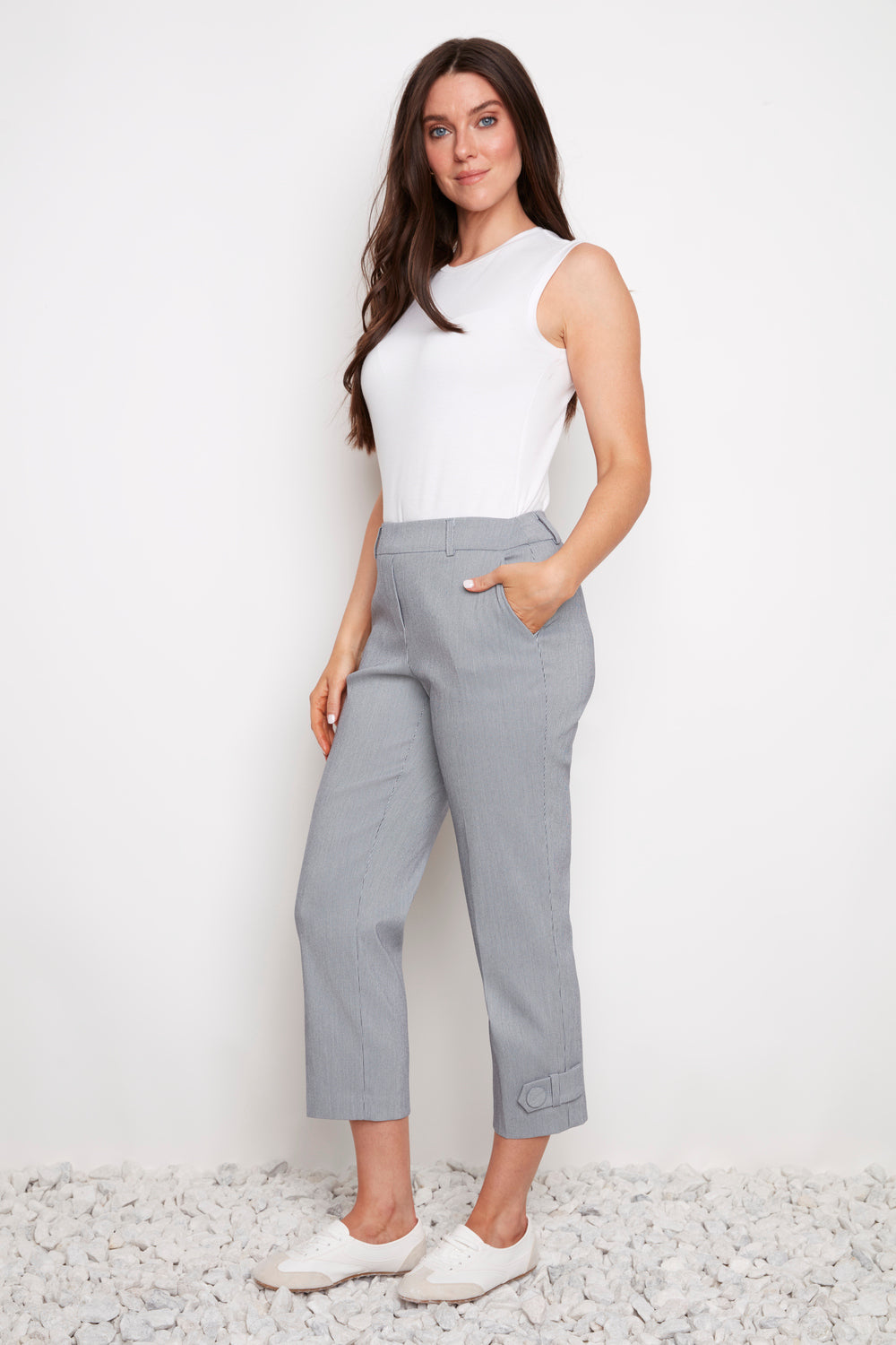 Light gray striped UP Techno Stripe 25" Tab Button Crop Pant by Up styled with a white sleeveless top and white shoes.