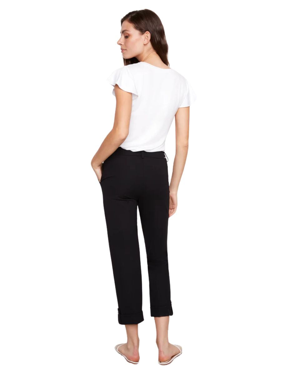 Slim black cropped pants paired with a white short-sleeve top and flat sandals on a white background.
