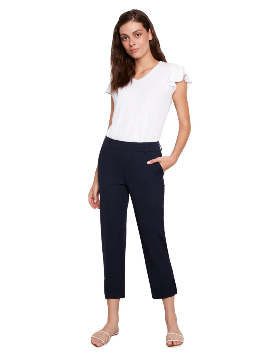 Model wearing Up UP Cool Compression Tab Button Hem 25" Pant in navy with a white blouse and sandals.