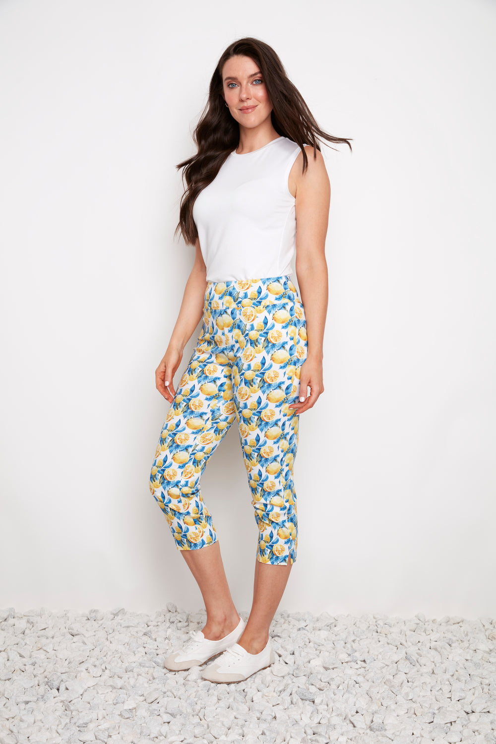 Model showcasing UP Techno Lemon 23" Side Slit Crop Pant by Up in bright lemon print with white sleeveless top and sneakers