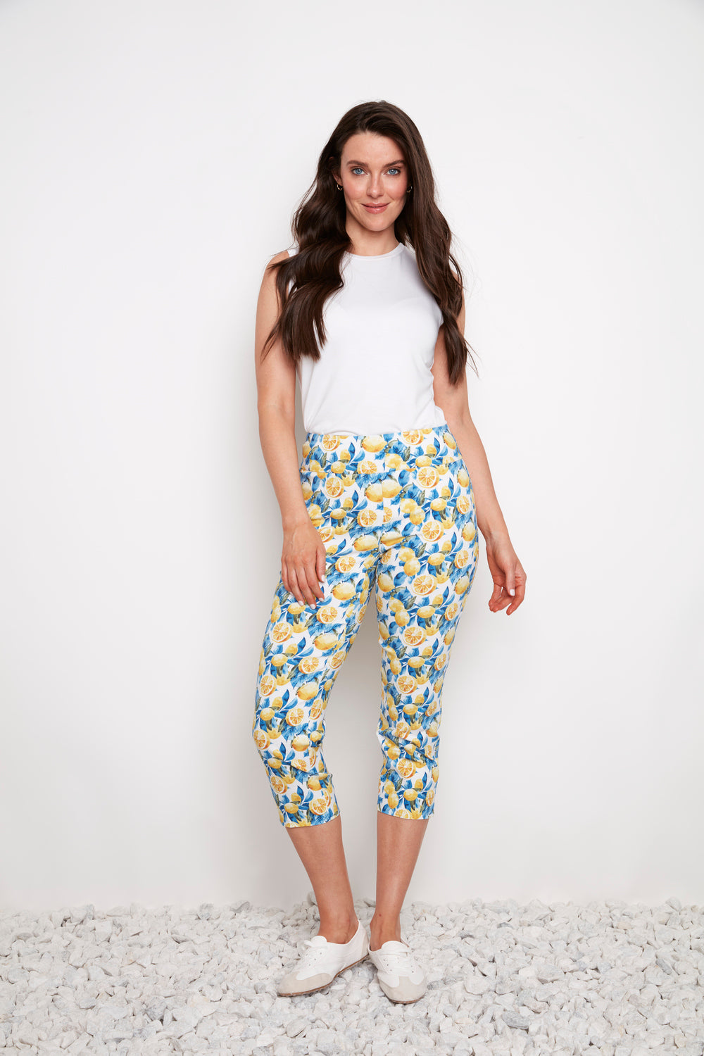 Model wearing UP Techno Lemon 23" Side Slit Crop Pant by Up with lemon print and white sneakers