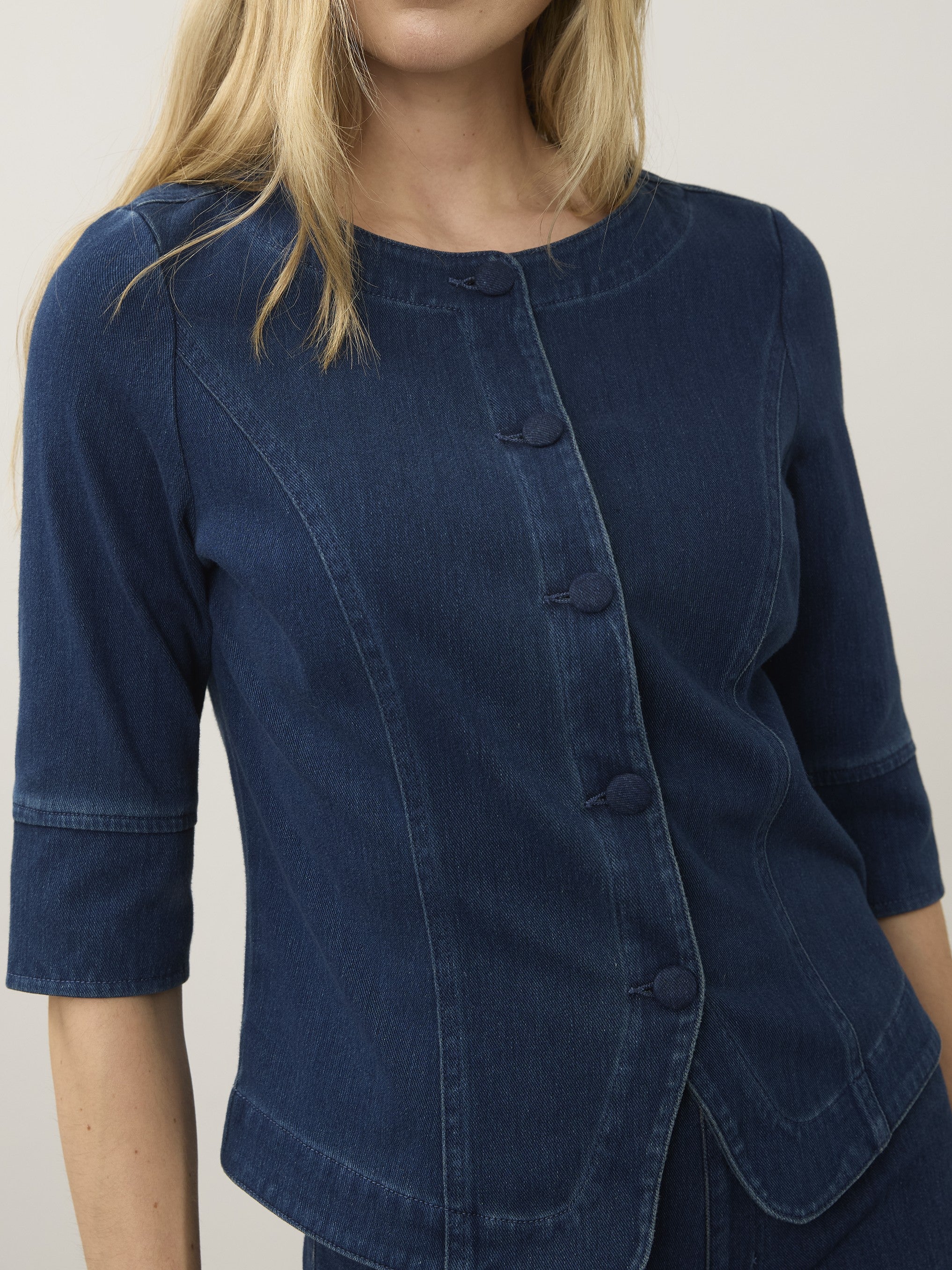 Dark blue denim jacket with three-quarter sleeves and fabric-covered buttons down the front panel.