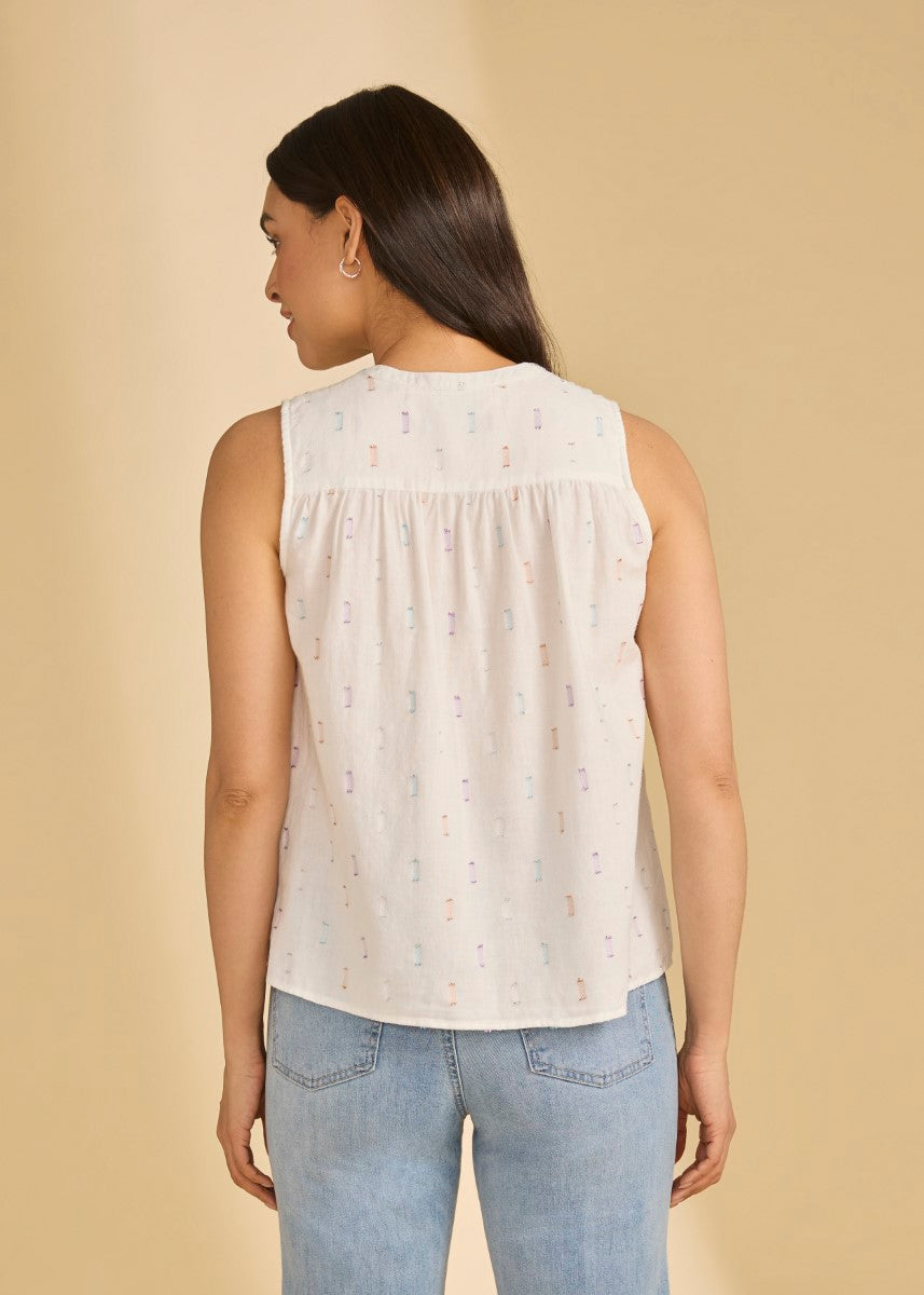Back view of sleeveless white top with subtle multicolor pattern paired with light blue jeans featuring the FDJ Metallic V-Neck Top by French Dressing