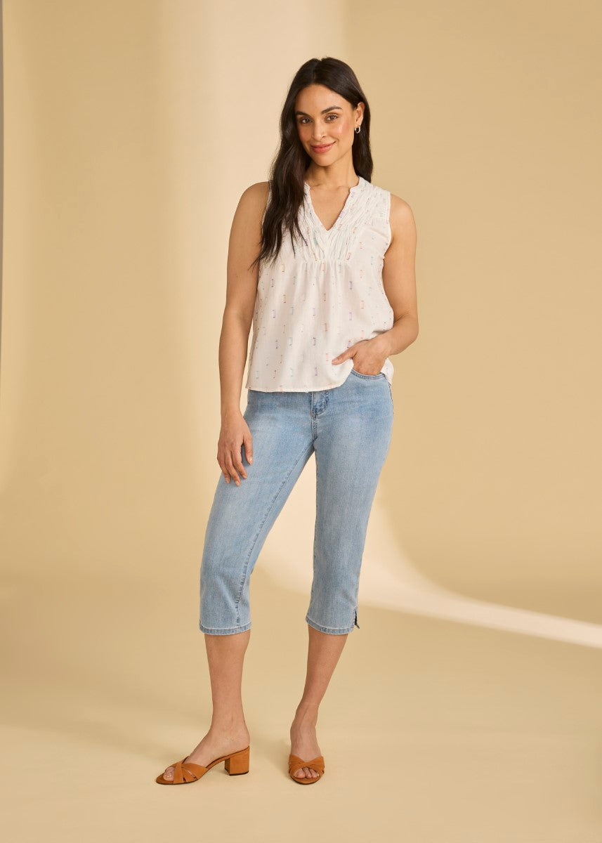 Light sleeveless blouse with subtle pattern paired with light blue cropped denim jeans and brown block-heeled sandals