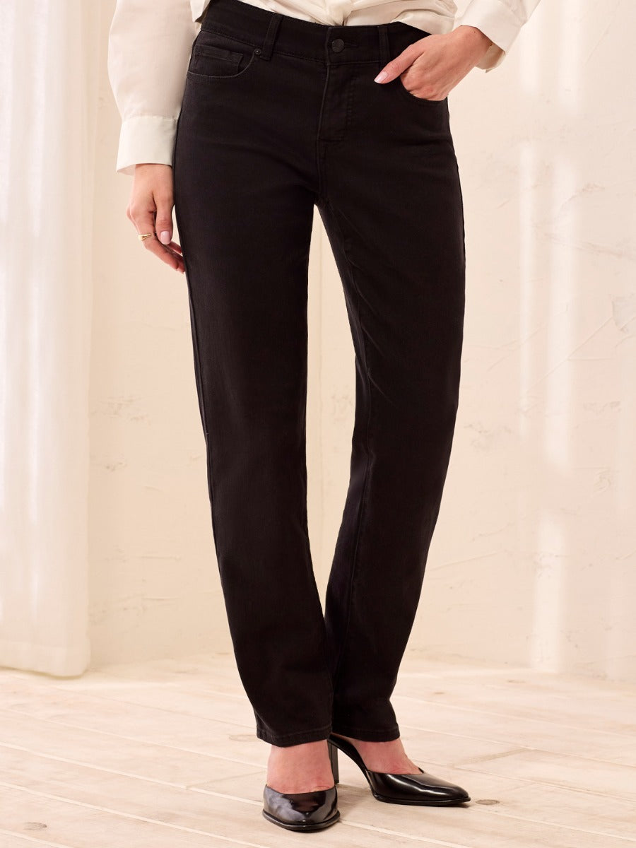 Black denim Tribal Sophia Curvy Straight Leg Jeans by Tribal Sportswear Inc. styled with black heels and white top.
