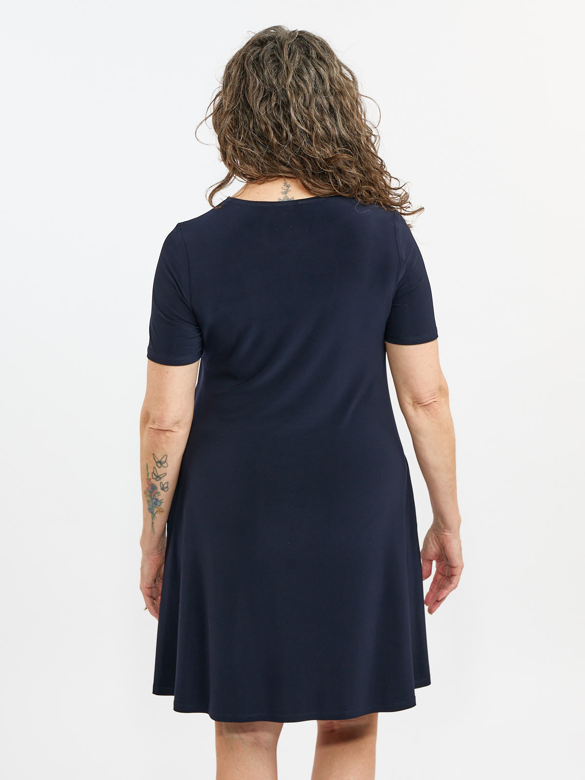 Sandra Short Sleeve Pocket A-Line Dress in navy by Bali Corp. shown from the back, featuring short sleeves and a relaxed fit.