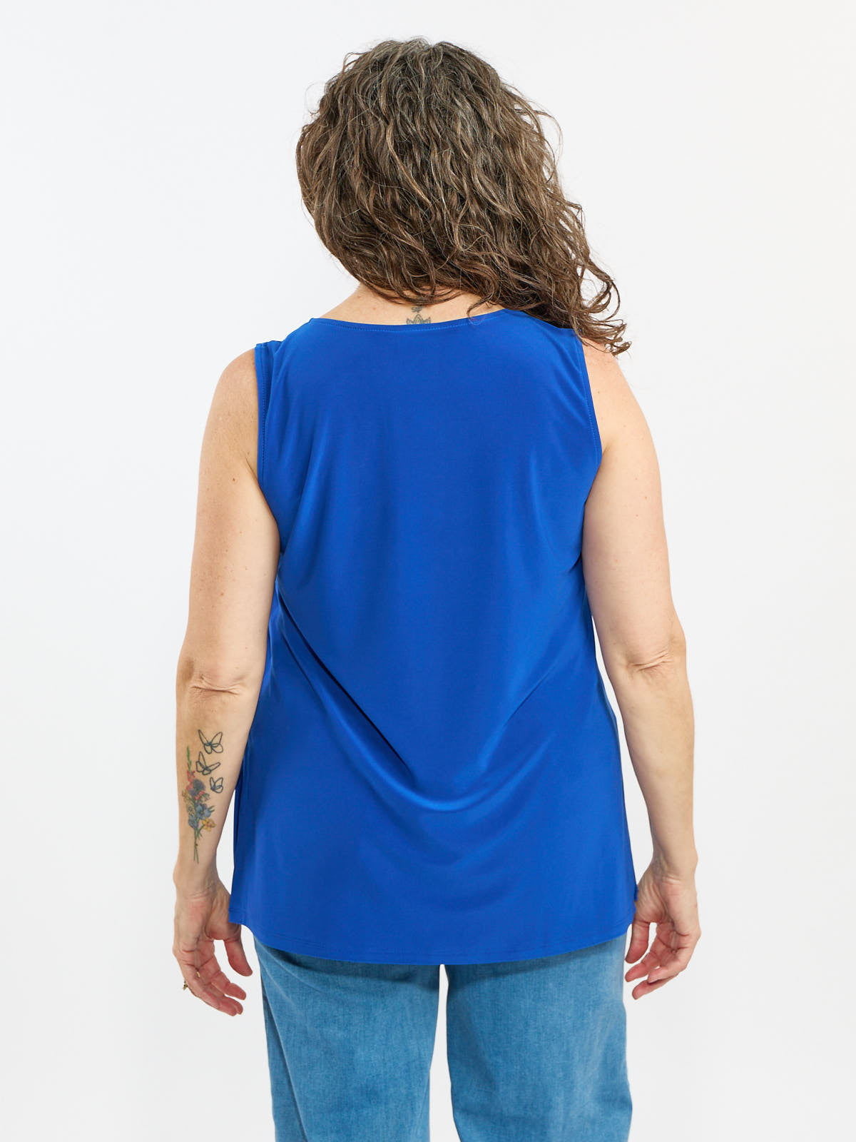 Back view of royal blue Liz Sleeveless Tank Side Slit Top by Bali Corp. paired with denim jeans.
