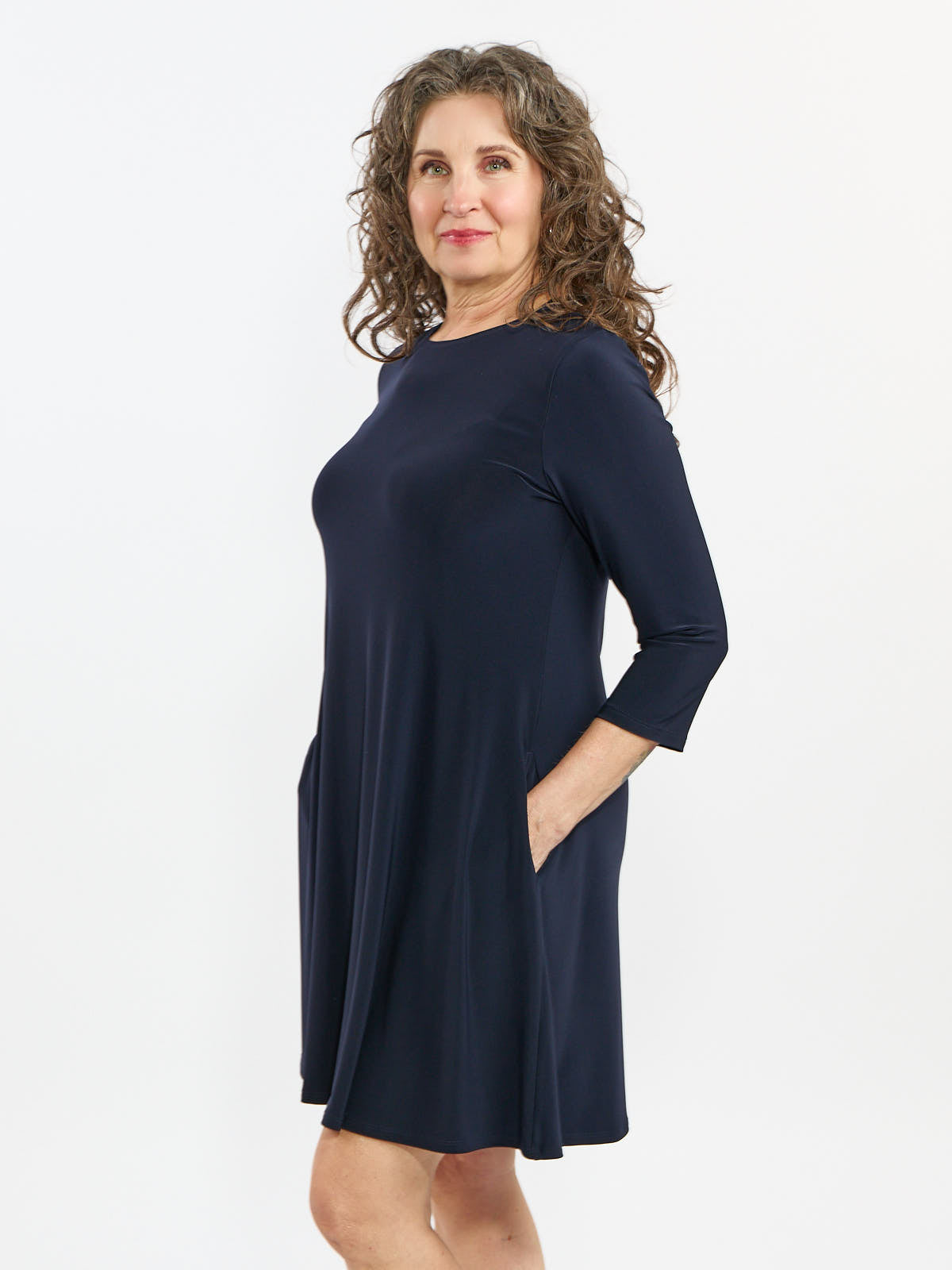Navy blue knee-length dress with three-quarter sleeves and side pockets on a white background.