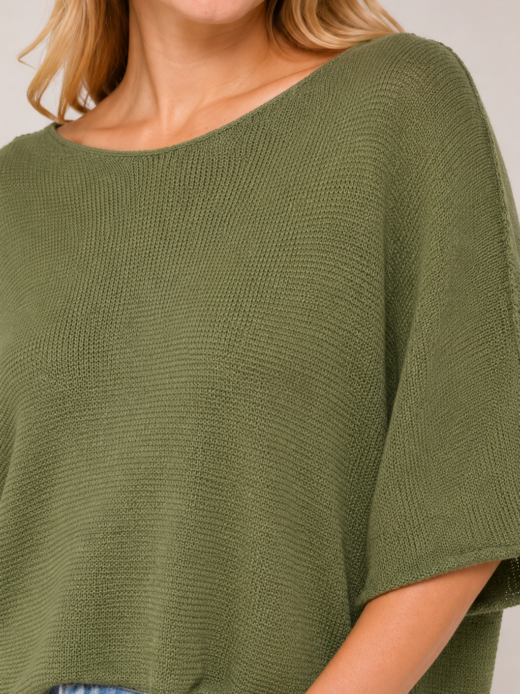 Green knit sweater with a wide neckline and a relaxed fit, shown from the shoulders to the waist.