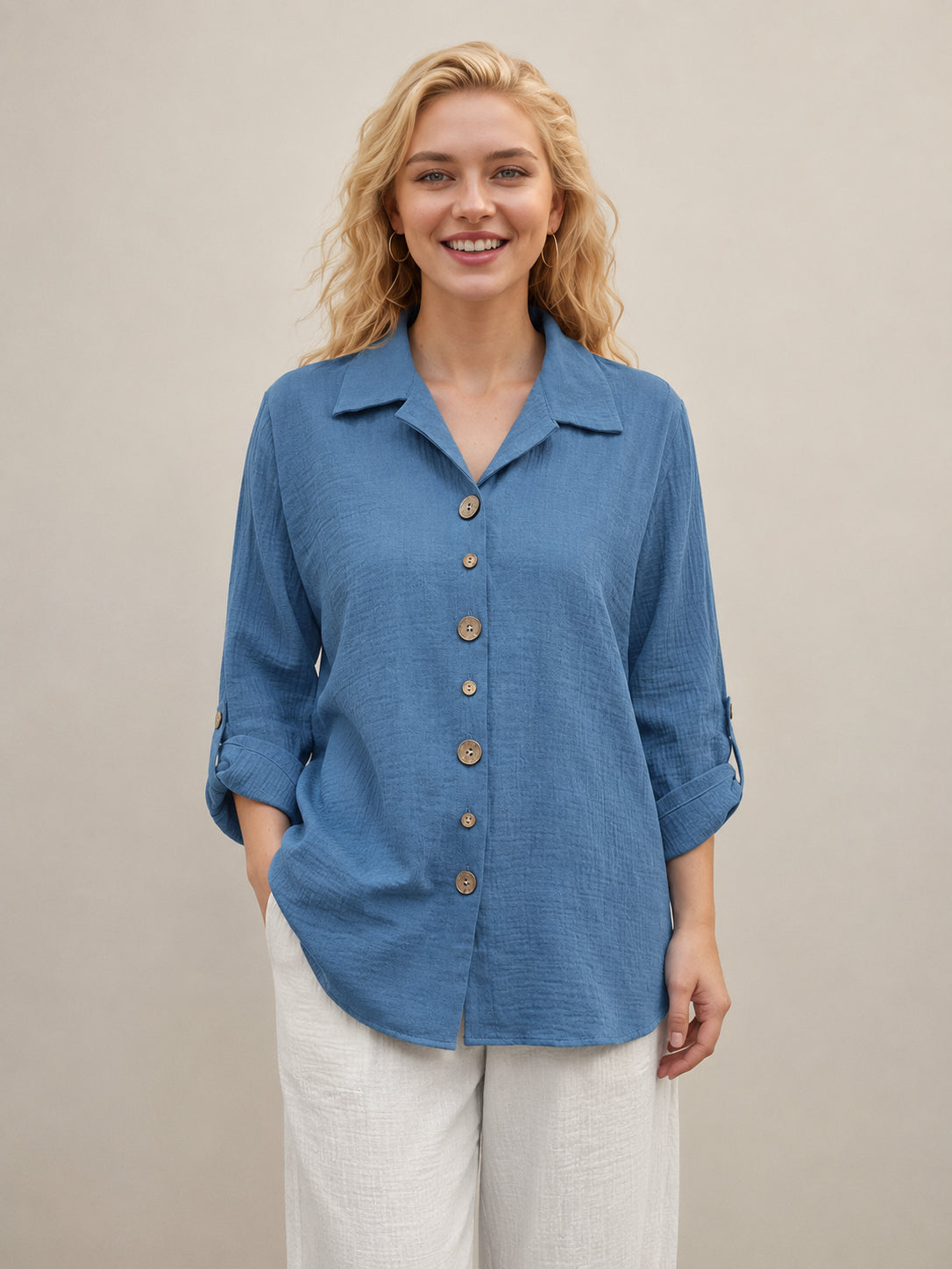 Creation Wooden Button Bubble Hem Top by Creations in blue with wooden buttons and textured fabric, paired with light trousers.