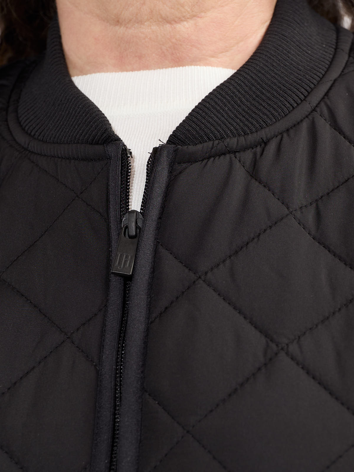 Close-up of black quilted texture and zipper detail on Ilse Jacobsen Quilted Vest outerwear garment