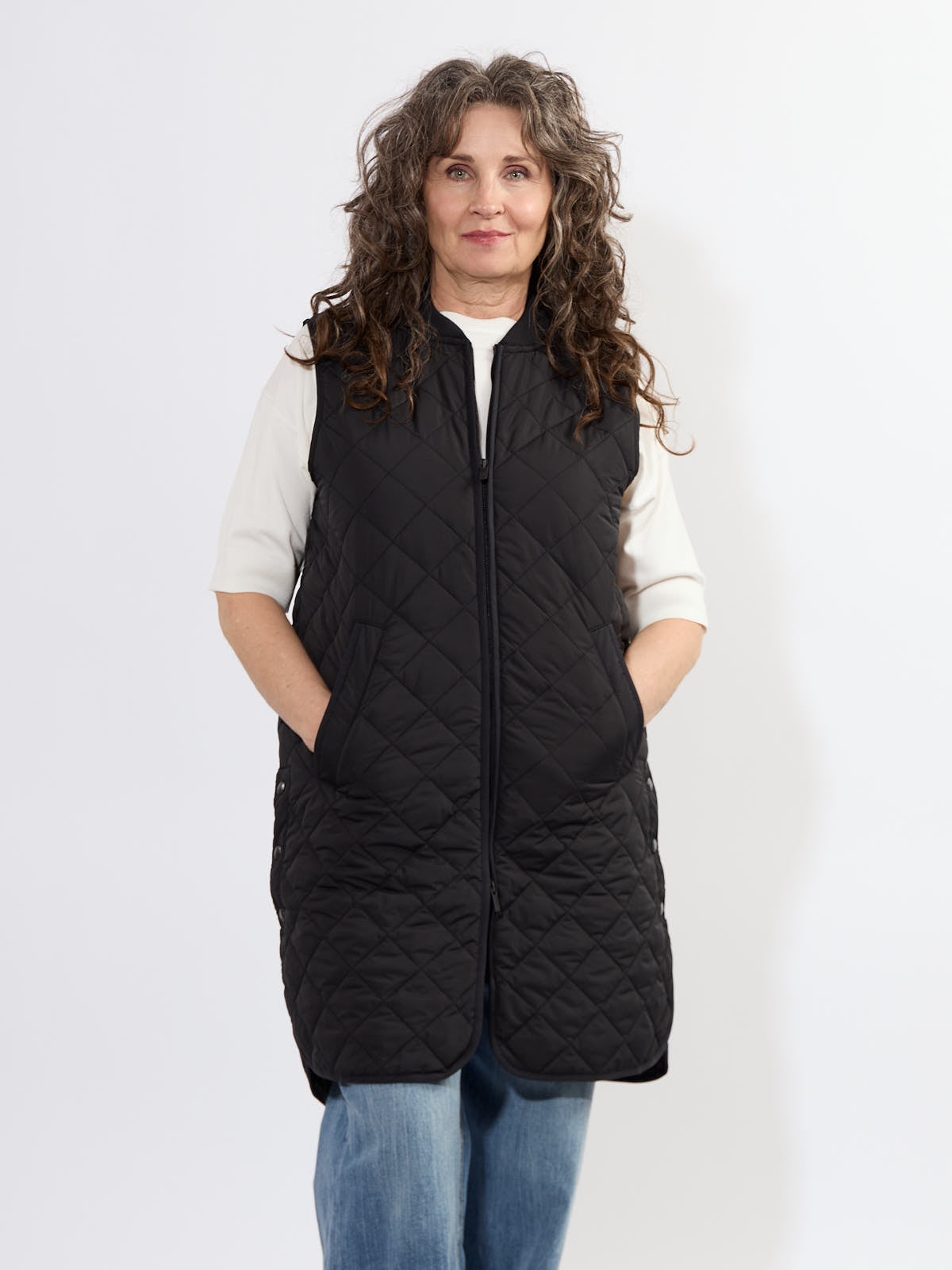 Ilse Jacobsen Quilted Vest in black, long sleeveless outerwear with front pockets, styled over a white top and jeans