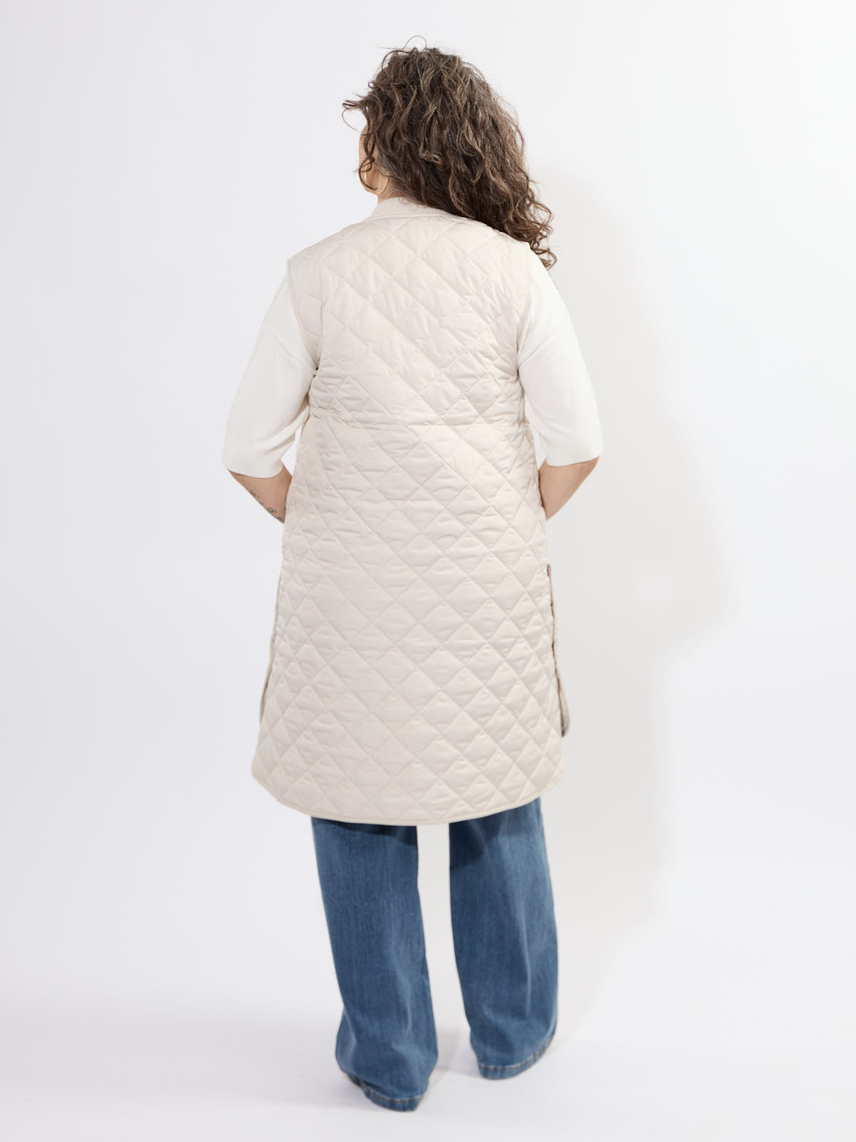 Back view of Ilse Jacobsen Quilted Vest in cream worn over white top and blue jeans by Ilse Jacobsen outerwear.