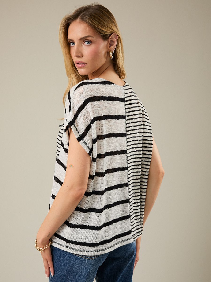 Woman wearing a black and white striped shirt against a beige background