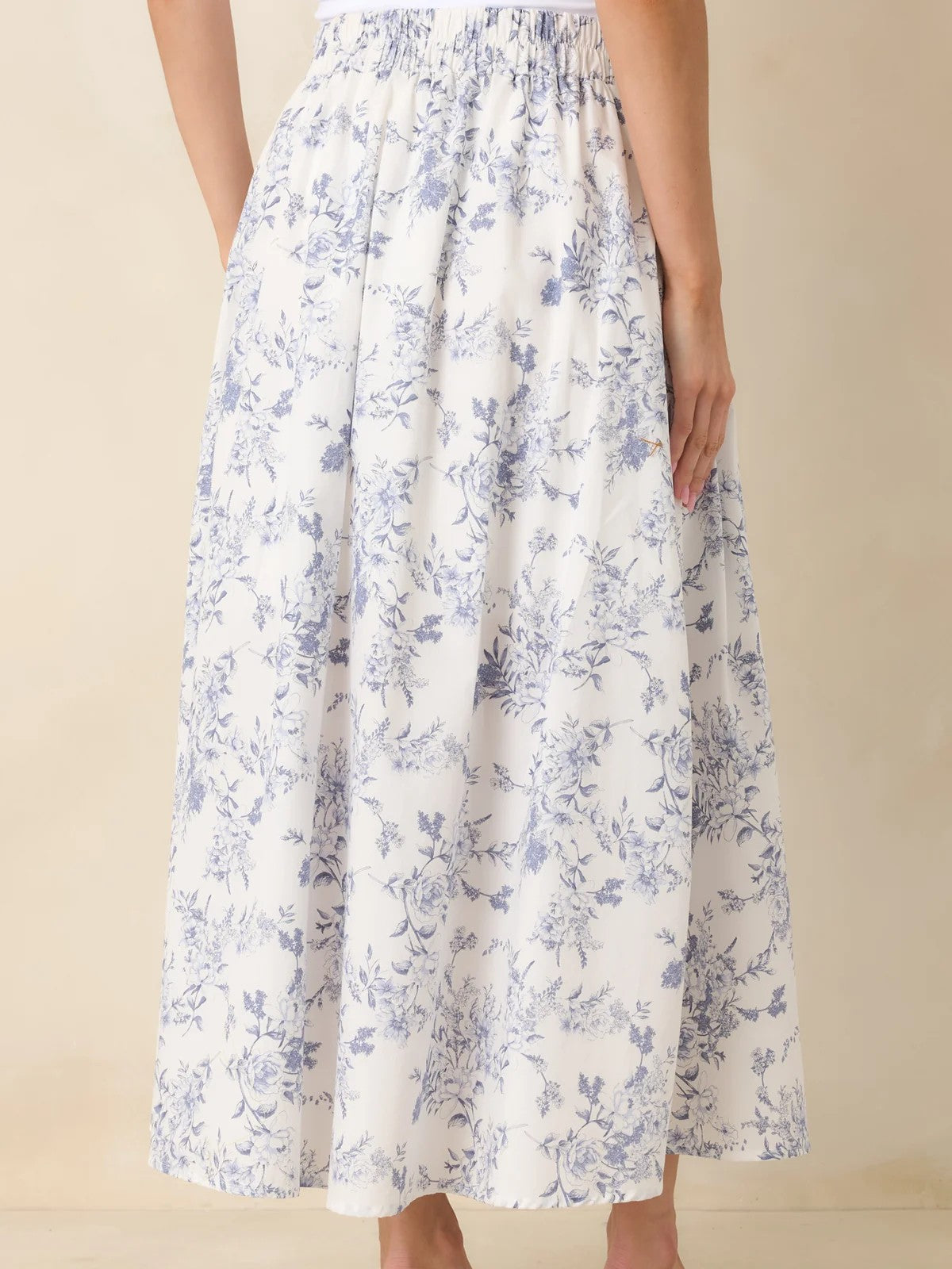 Long white skirt with light blue floral print and elastic waistband shown from the back
