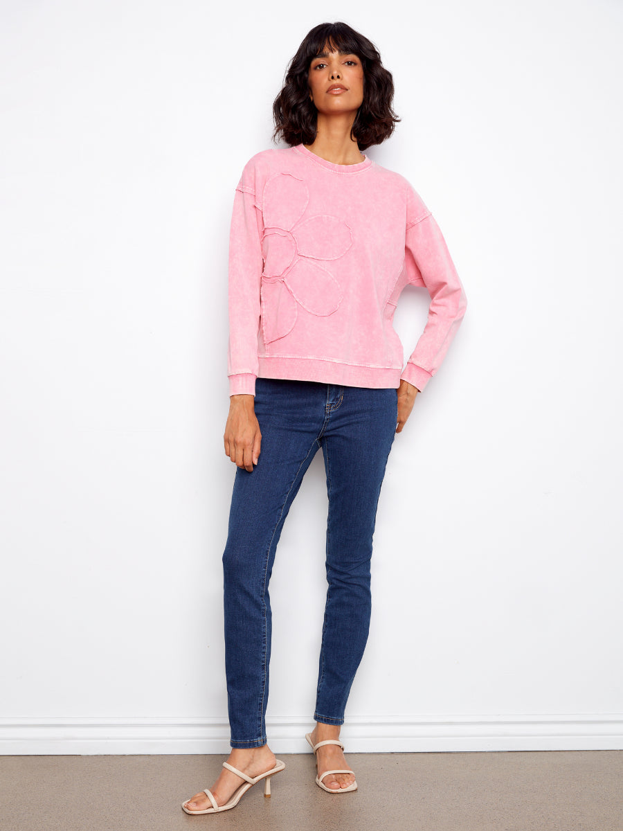 Charlie B Daisy Washed Terry Crew Neck Sweatshirt in pink with floral detail, styled with dark blue skinny jeans and sandals
