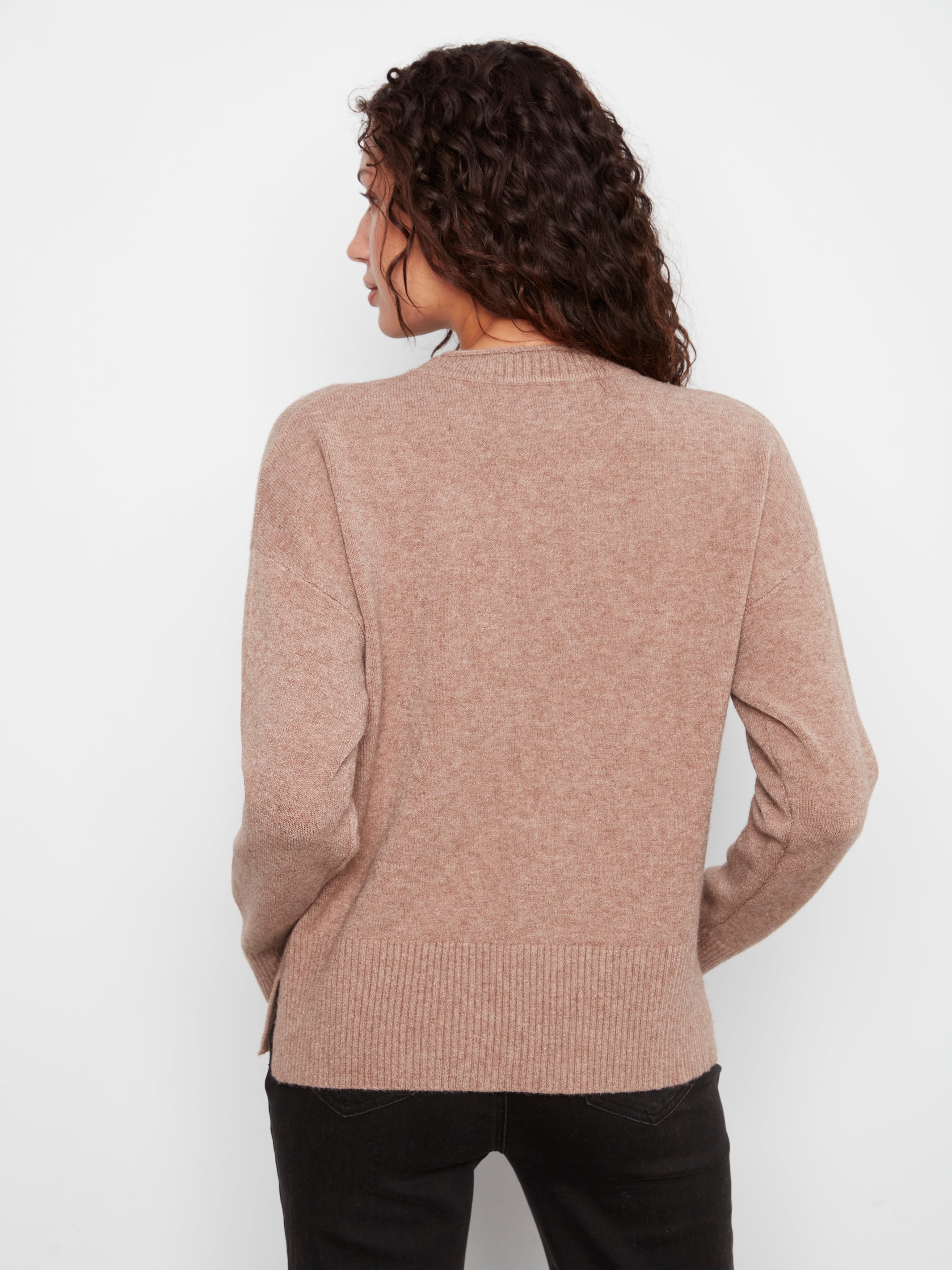 Back view of a light brown knitted sweater with ribbed hem and cuffs on a white background