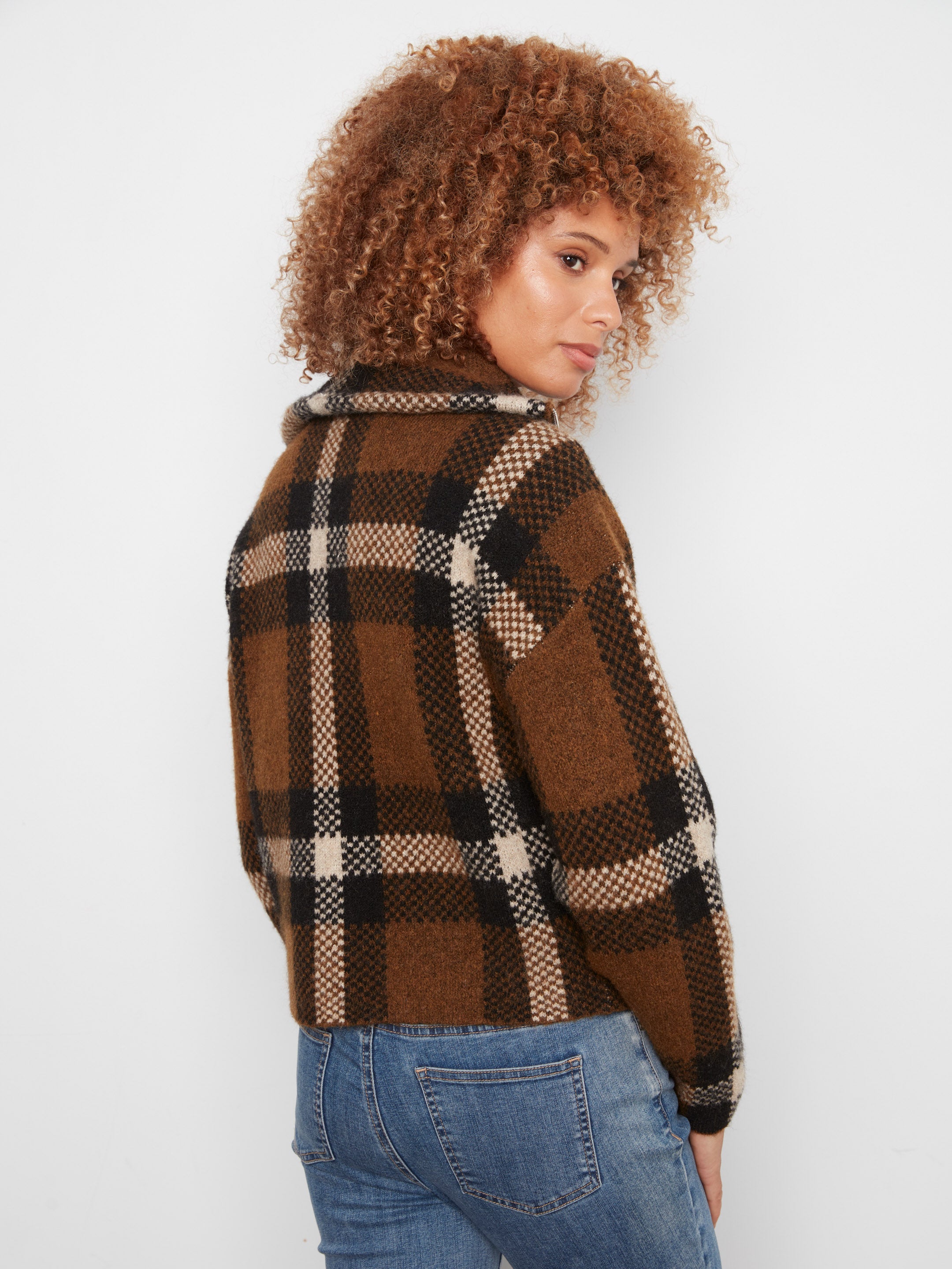 Brown and black plaid wool jacket paired with blue denim jeans on a light background