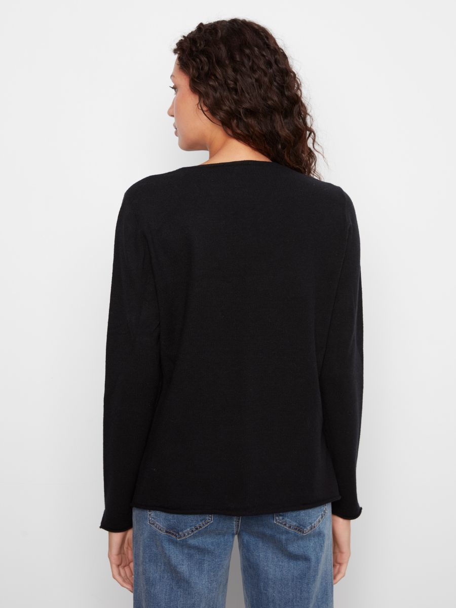 Back view of a black Charlie B Jenny Plushy V-Neck Sweater paired with blue denim jeans by Charlie B.