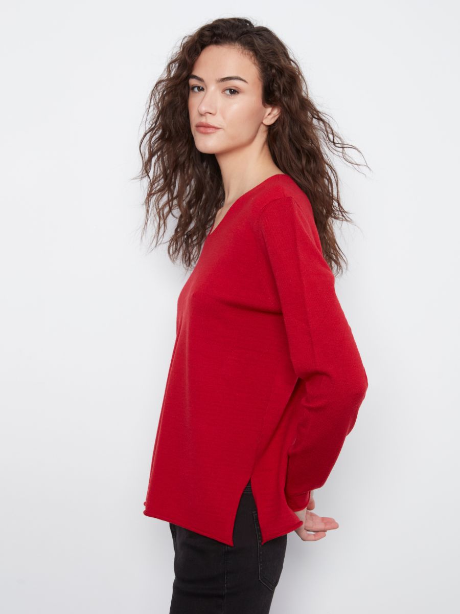 Side view of a loose red long-sleeve top paired with black pants against a plain white background.