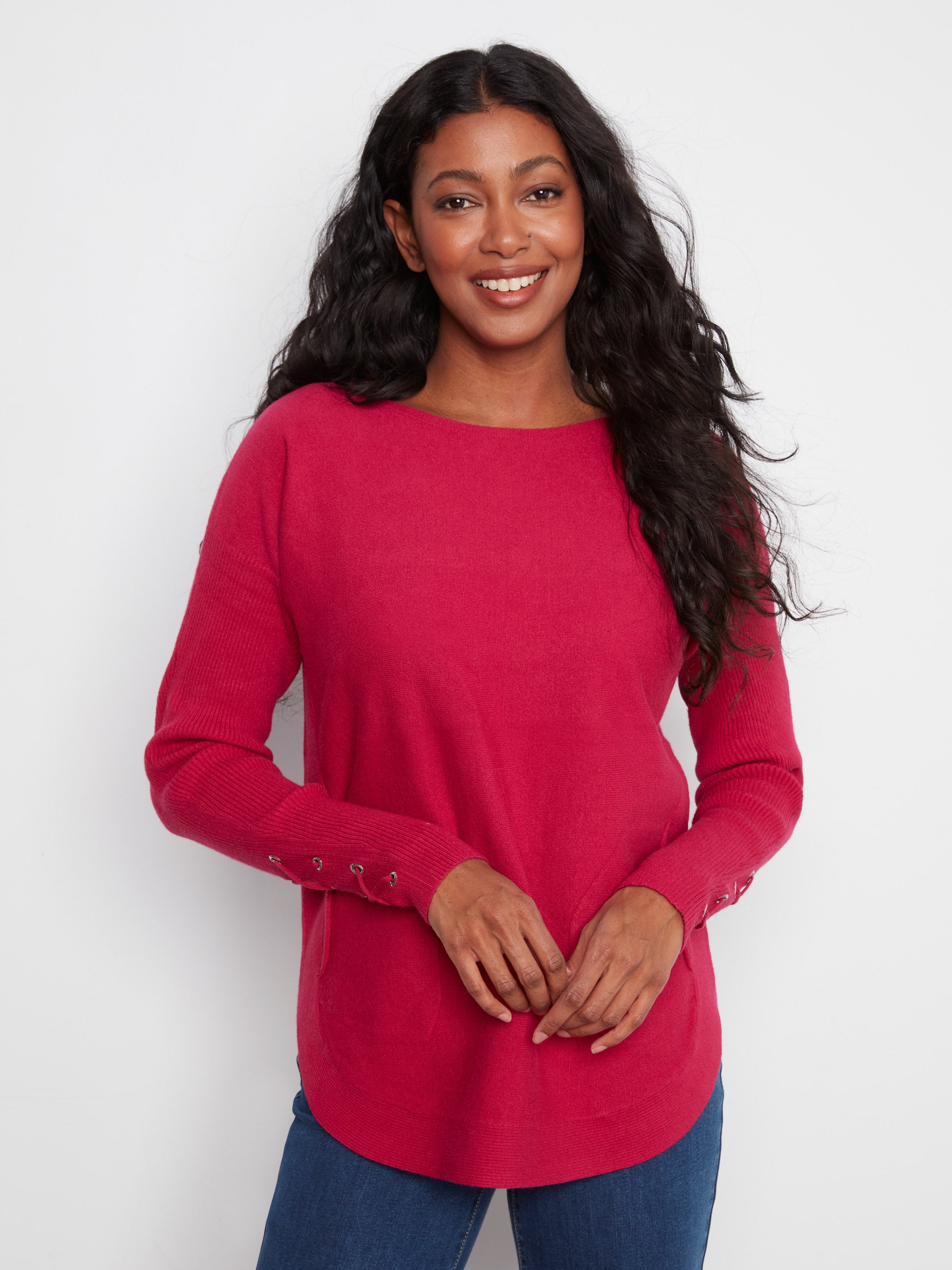 Smiling figure in a bright red long-sleeve sweater with button detailing on sleeves against a plain background