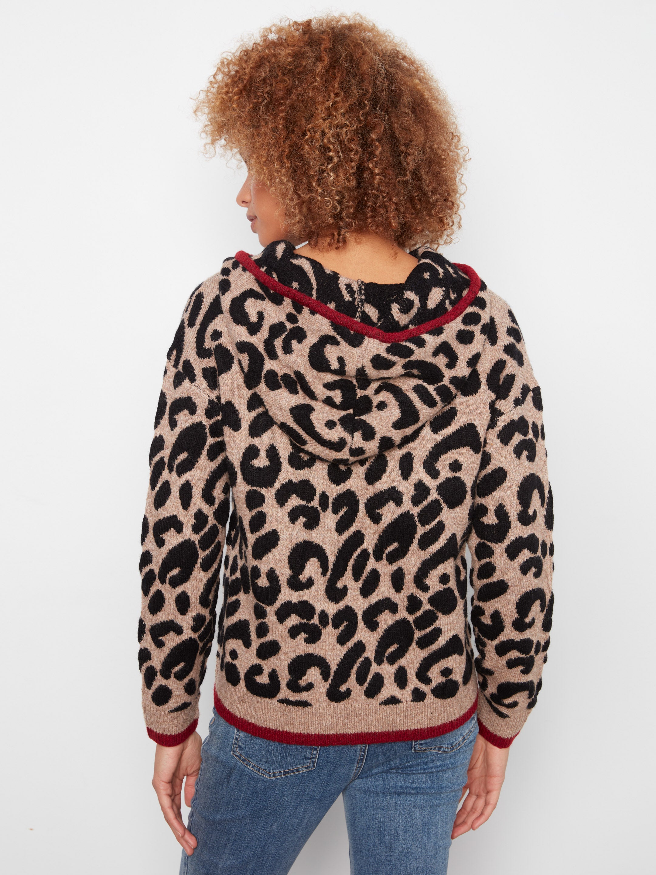 Leopard print hooded sweater with burgundy trim worn with blue denim jeans, viewed from back.