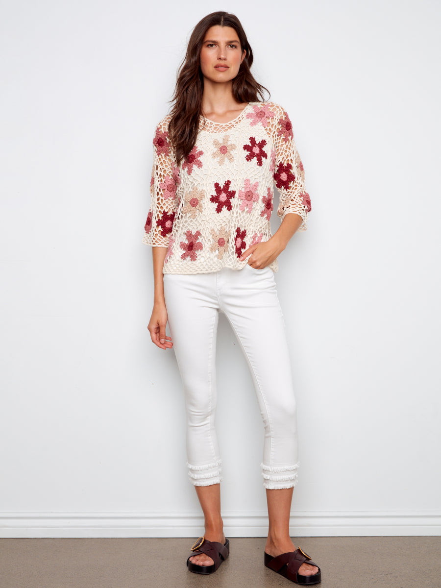 Model showcasing Charlie B Color My Daisy Three-Quarter Sleeve Crochet Top with floral crochet design in white and red tones