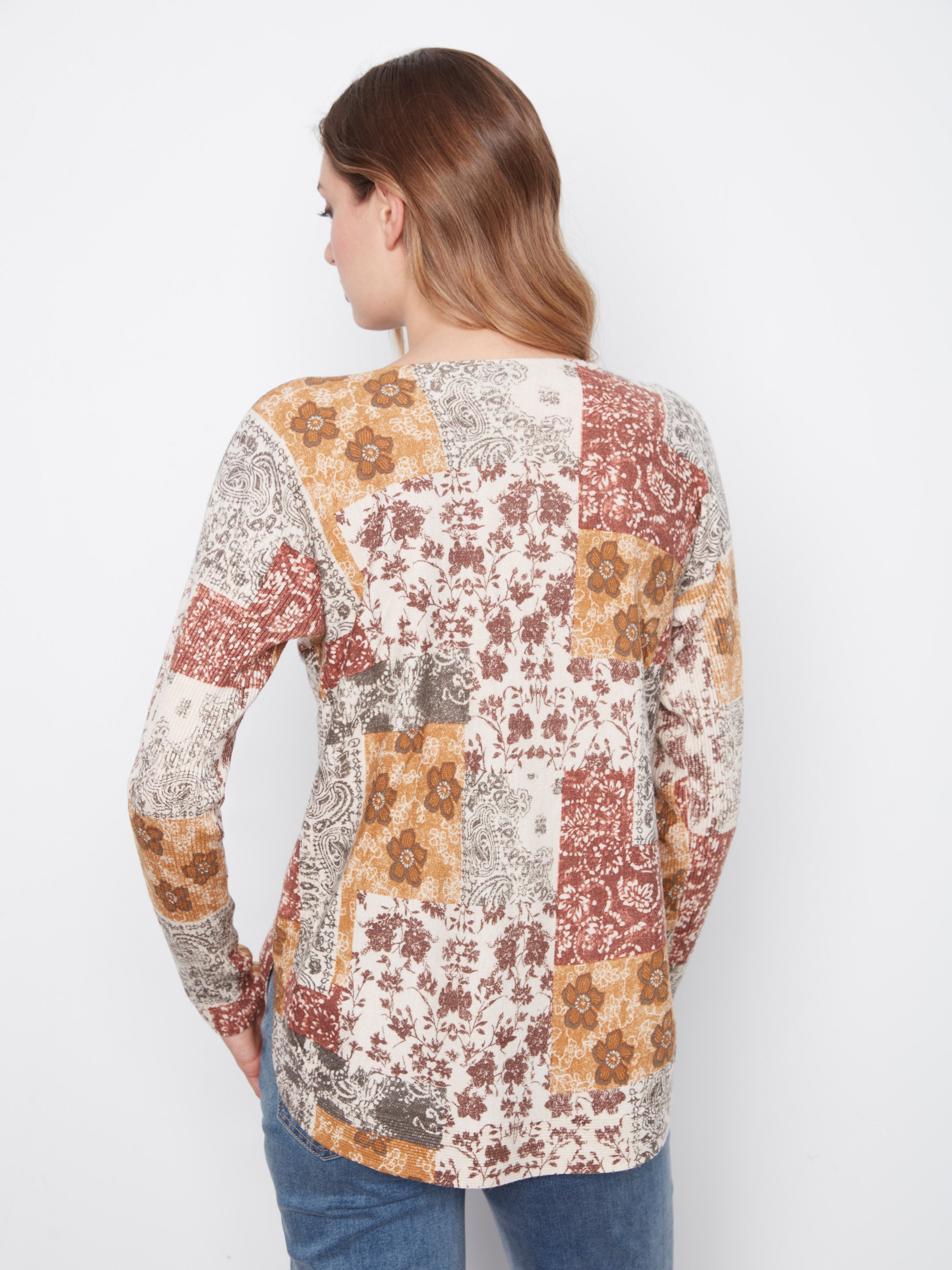 Back view of a long-sleeve top with a multicolored floral and paisley patchwork pattern