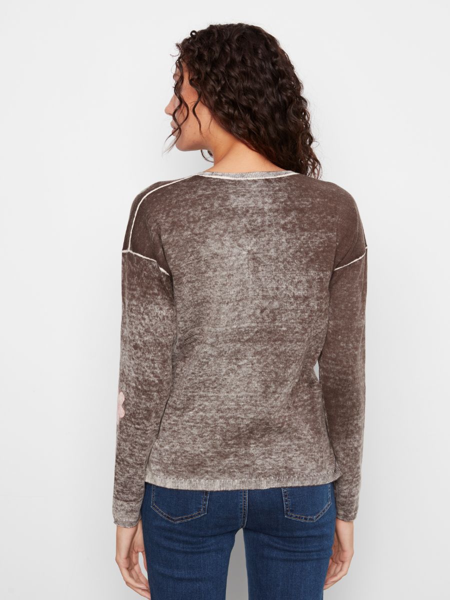 Back view of a brown textured long-sleeve sweater with visible seam details paired with blue denim jeans.