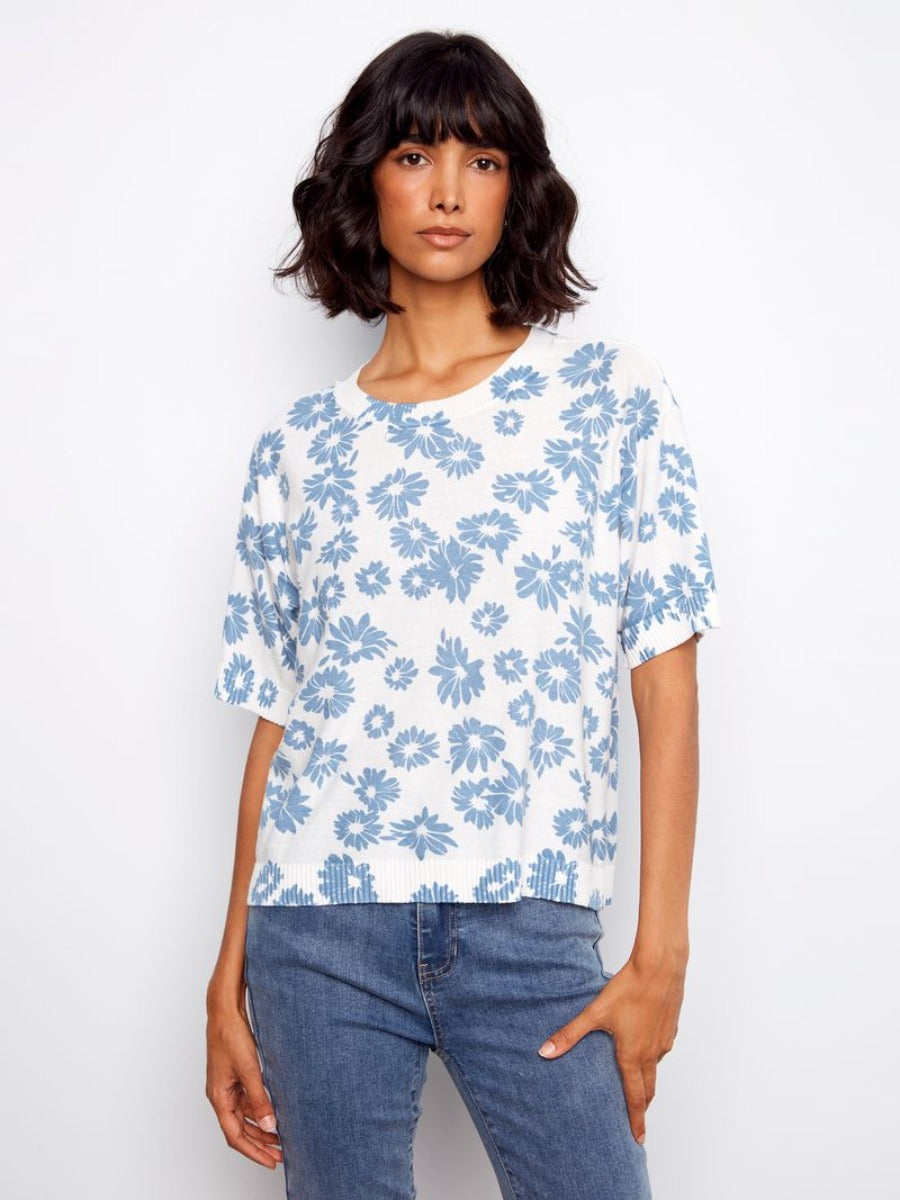 Charlie B Skylar Petal Crochet Short Sleeve Sweater in white with blue floral pattern, styled with denim jeans