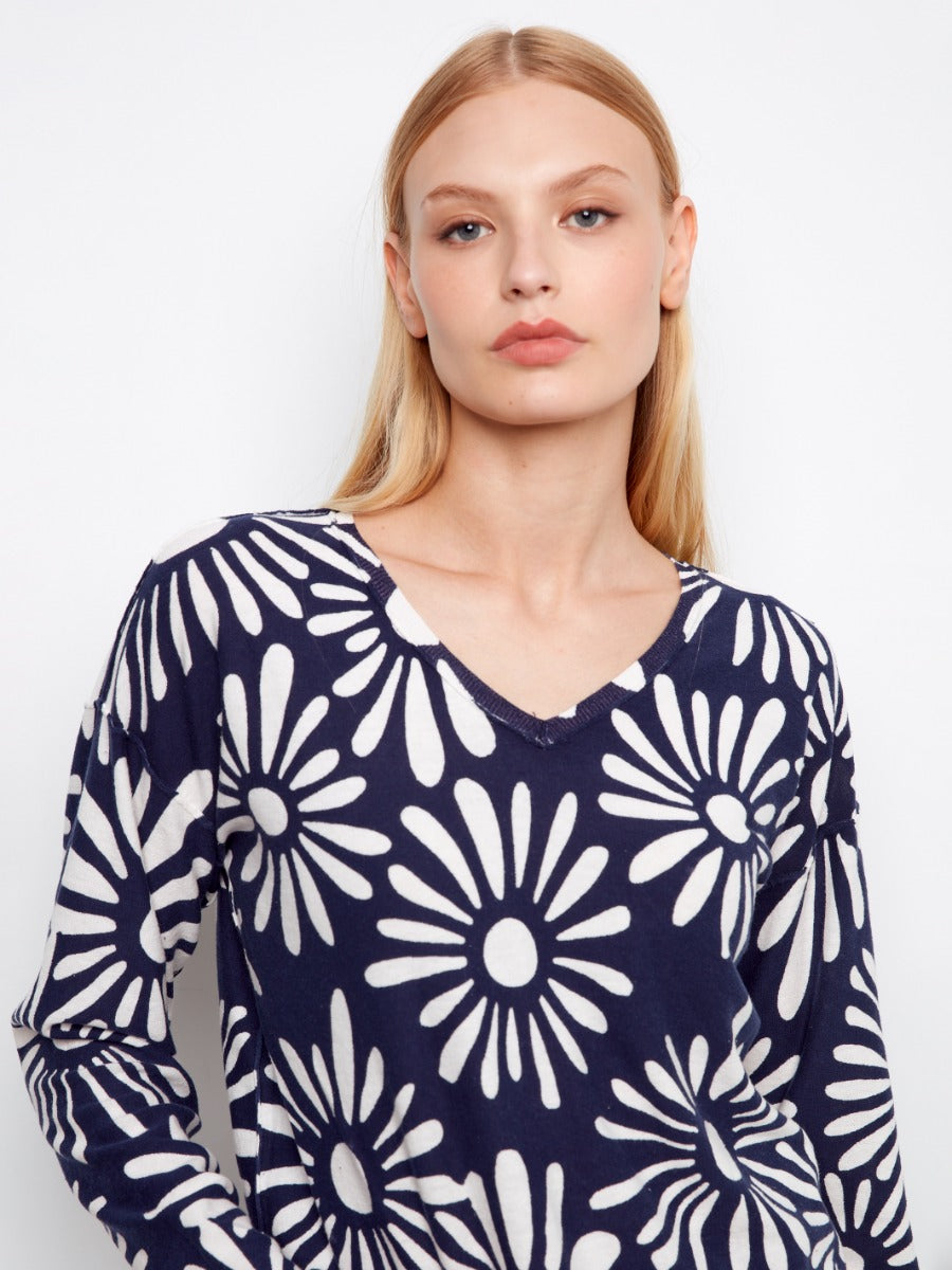 Close-up of model in Charlie B Suns Out Ribbed Cotton V-Neck Sweater featuring navy blue and white floral pattern by Charlie B
