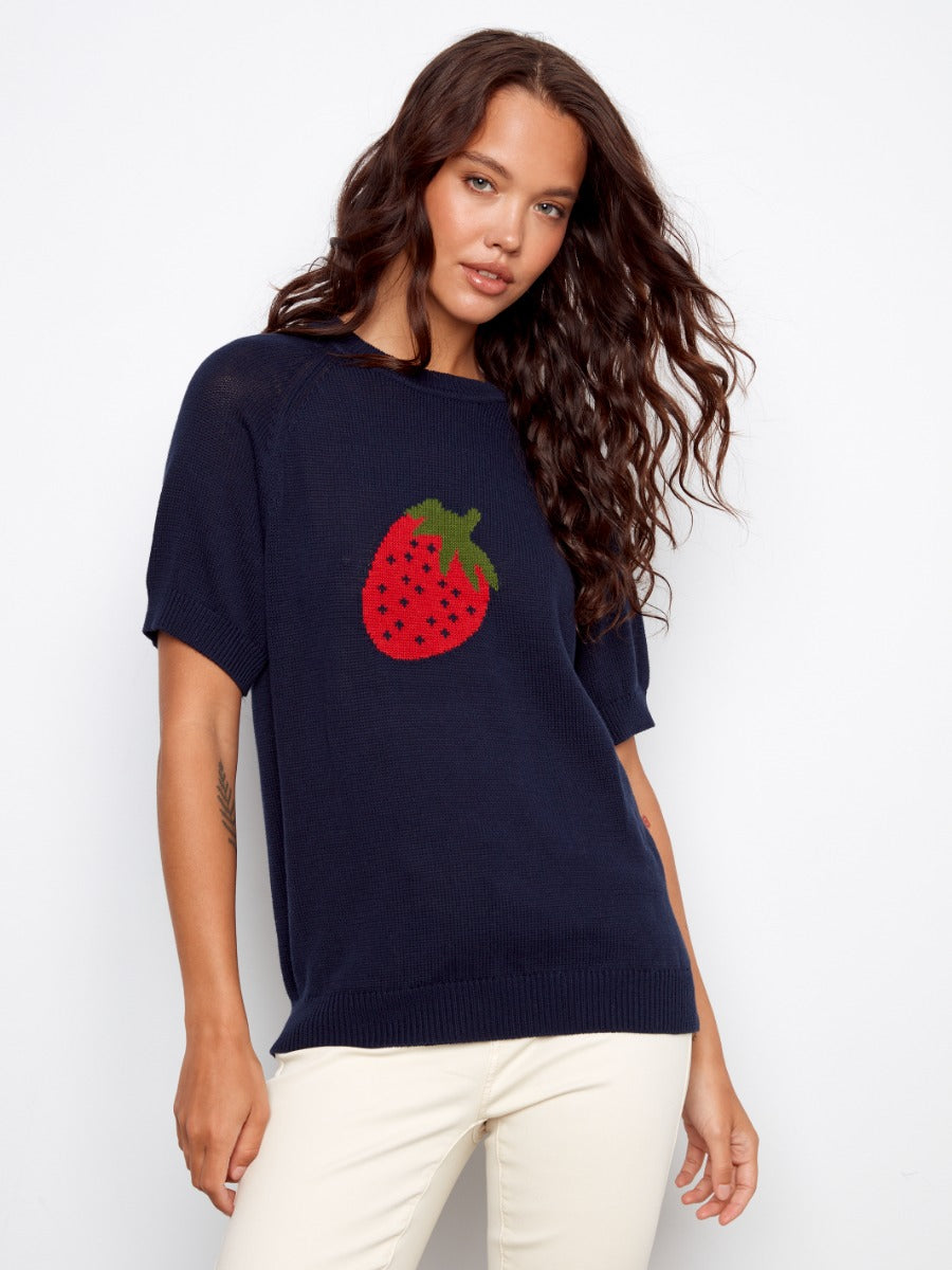 Charlie B Strawberry Short Sleeve Crochet Sweater in navy with a strawberry design, styled with light pants by Charlie B.