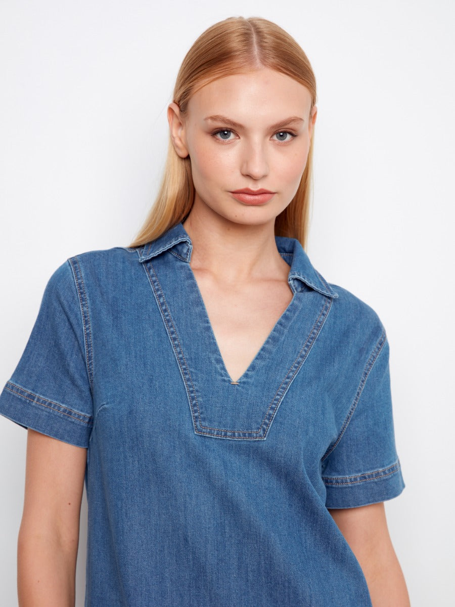 Close-up of a model in a Charlie B Double Pocket Short Sleeve Denim Dress in classic blue denim by Charlie B.