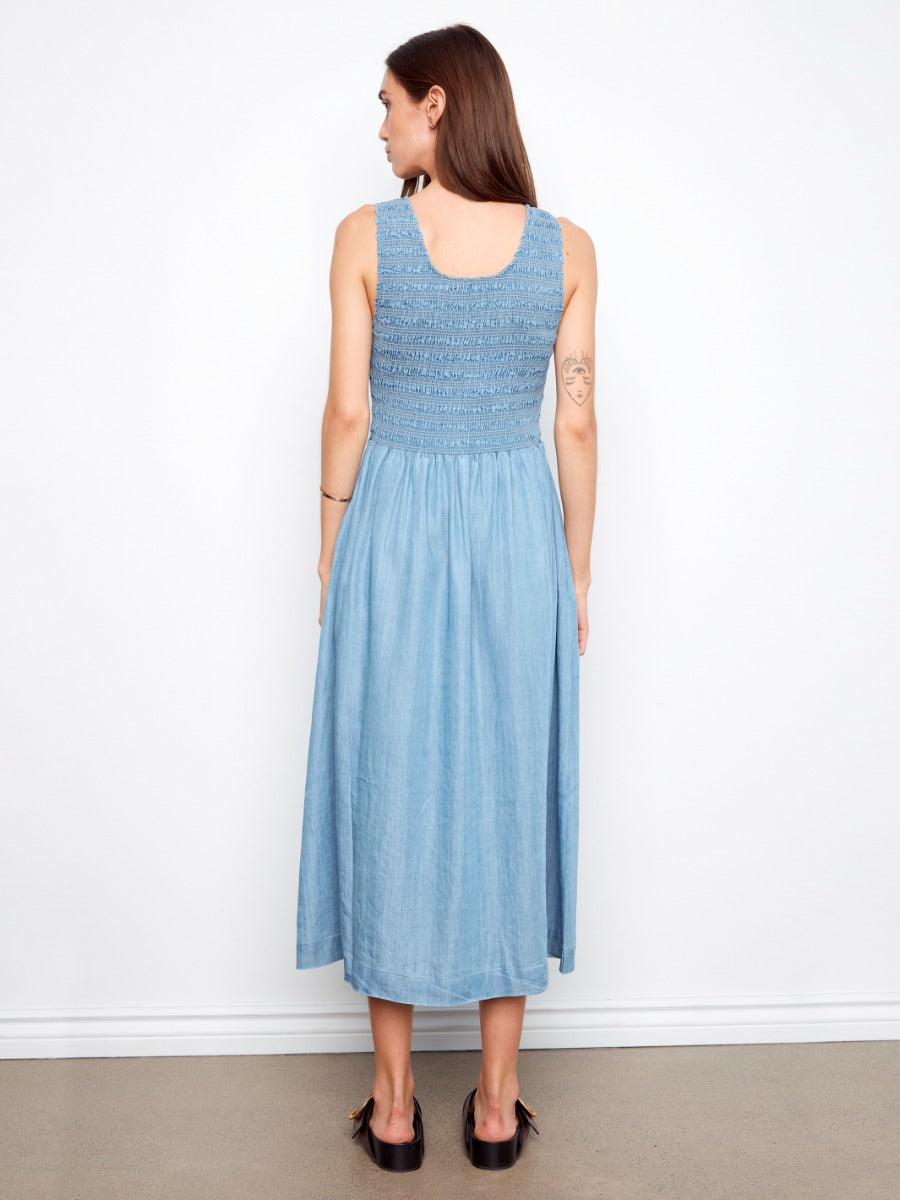 Back view of Charlie B Solstice Tencel Smocked Midi Dress in blue, featuring a smocked bodice and flowy skirt.