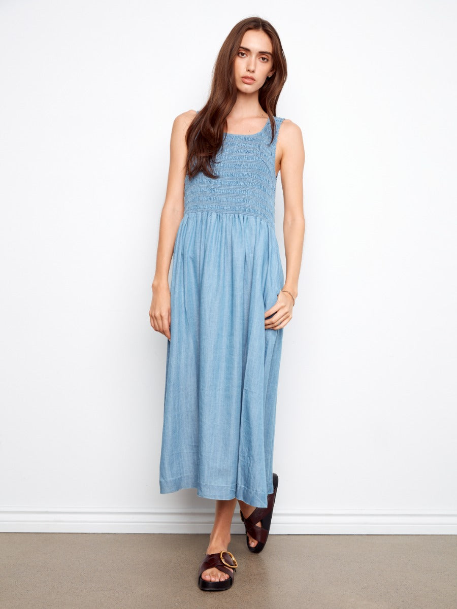 Blue midi dress with smocked bodice and straps by Charlie B, styled with dark brown sandals, Charlie B Solstice Tencel Smocked Midi Dress