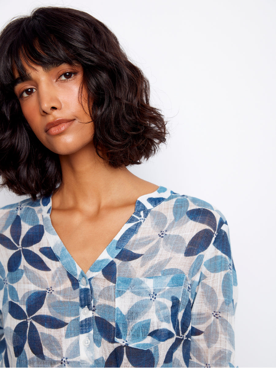 Close-up of a floral blue textured gauze top shirt showcasing Charlie B Johanna Floral Textured Gauze Roll Sleeve Top