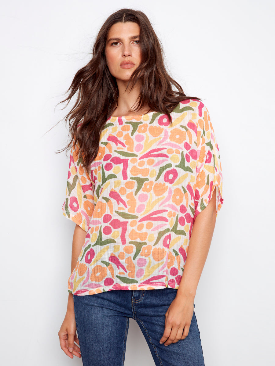 Charlie B Solstice Cotton Gauze Short Sleeve Top in colorful floral pattern paired with blue denim jeans by Charlie B.