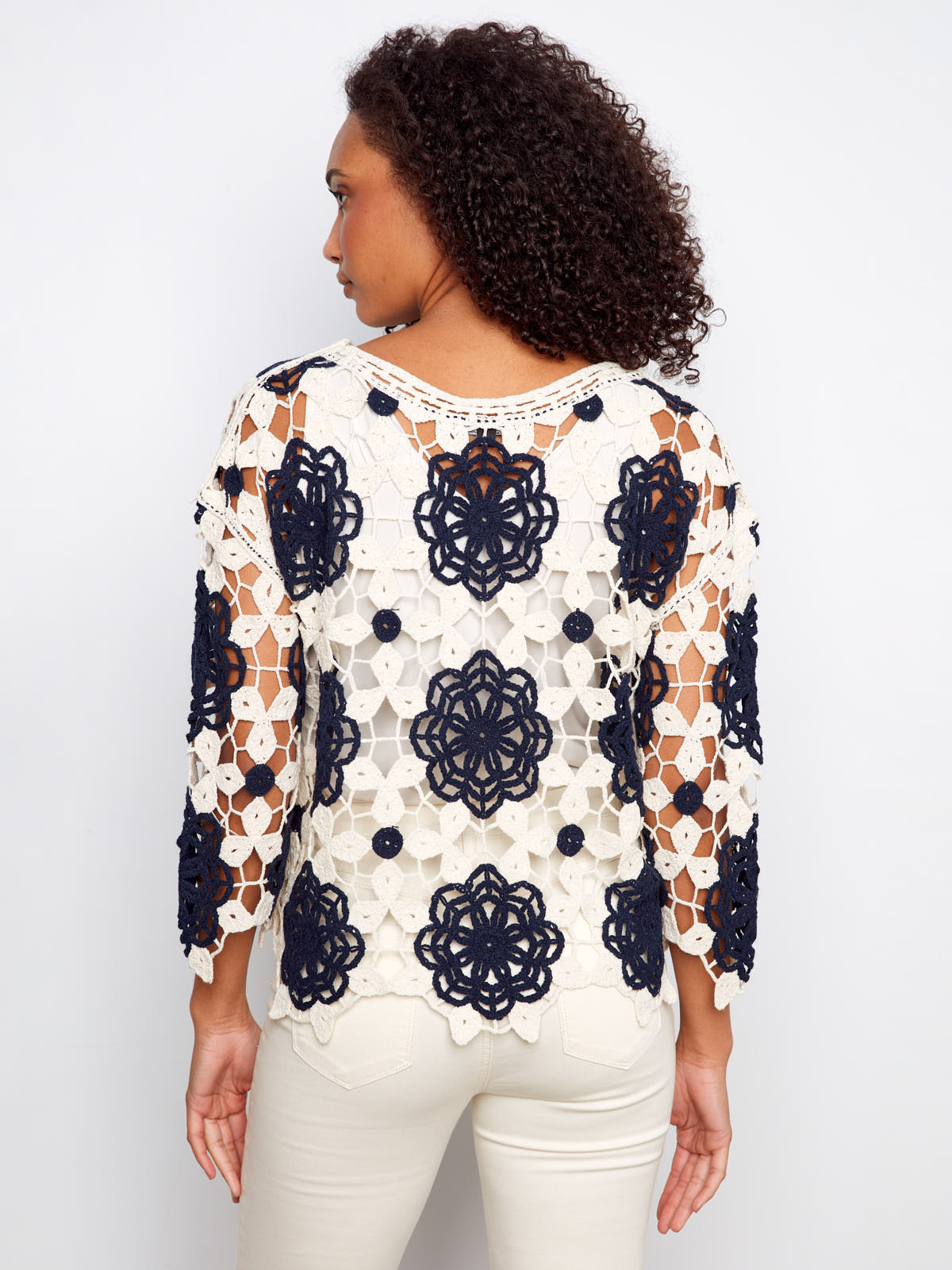 Back view of a crochet top with navy floral patterns on white, featuring Charlie B Flower Crochet Crew Top by Charlie B