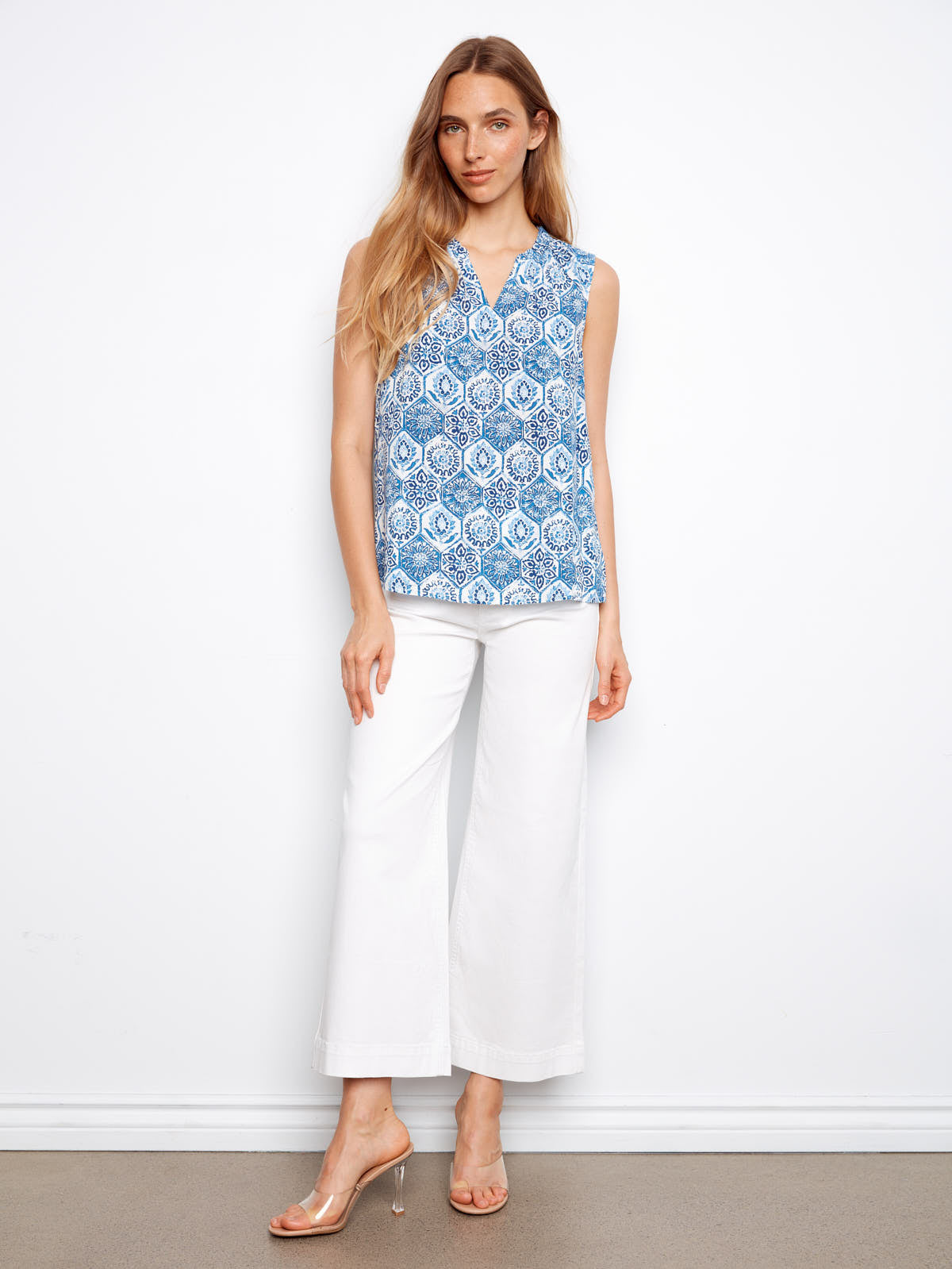 Charlie B Layered or Not Ruffle Top in blue patterned sleeveless design styled with white wide-leg pants and clear heels